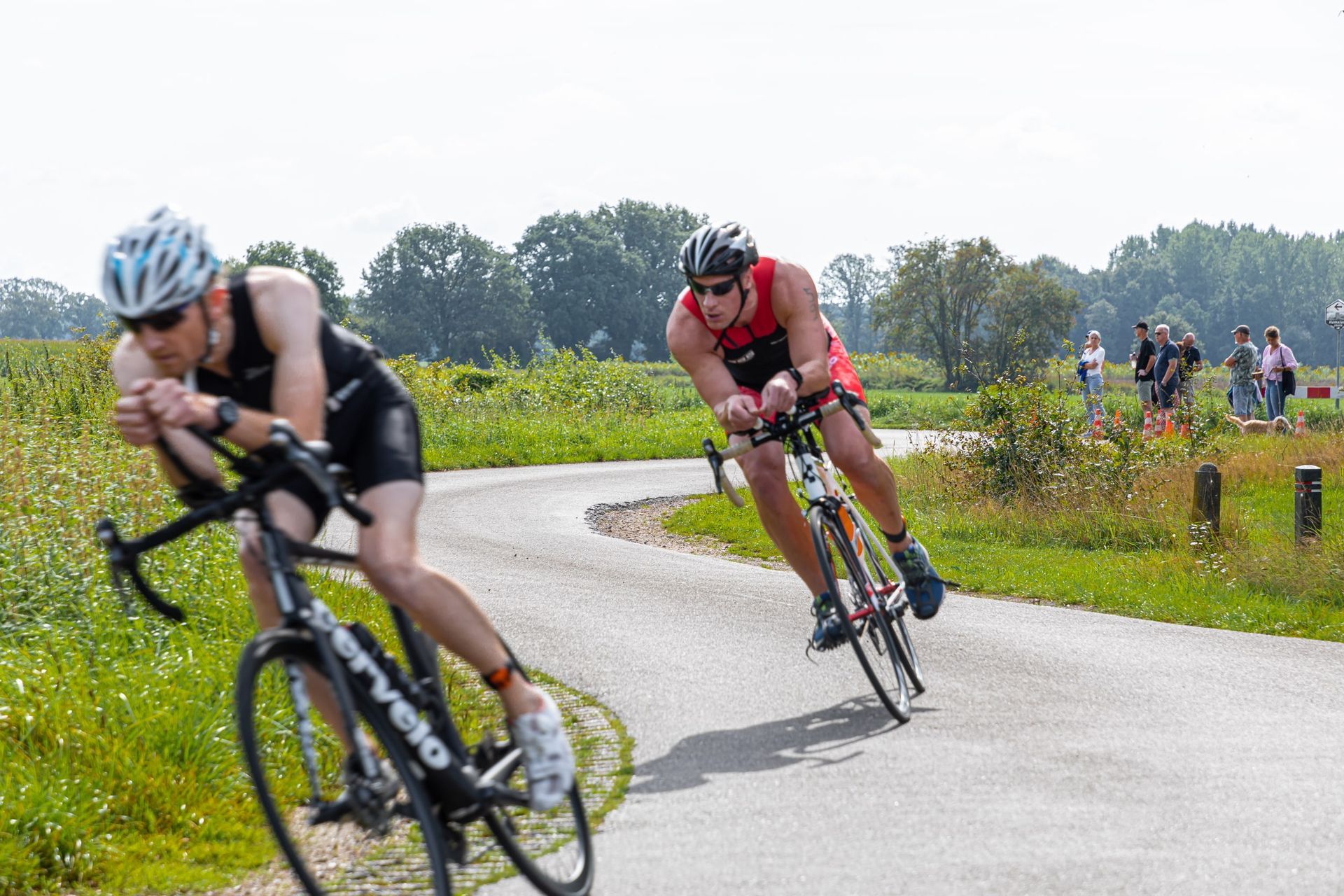 Twee mannen fietsen over een weg.