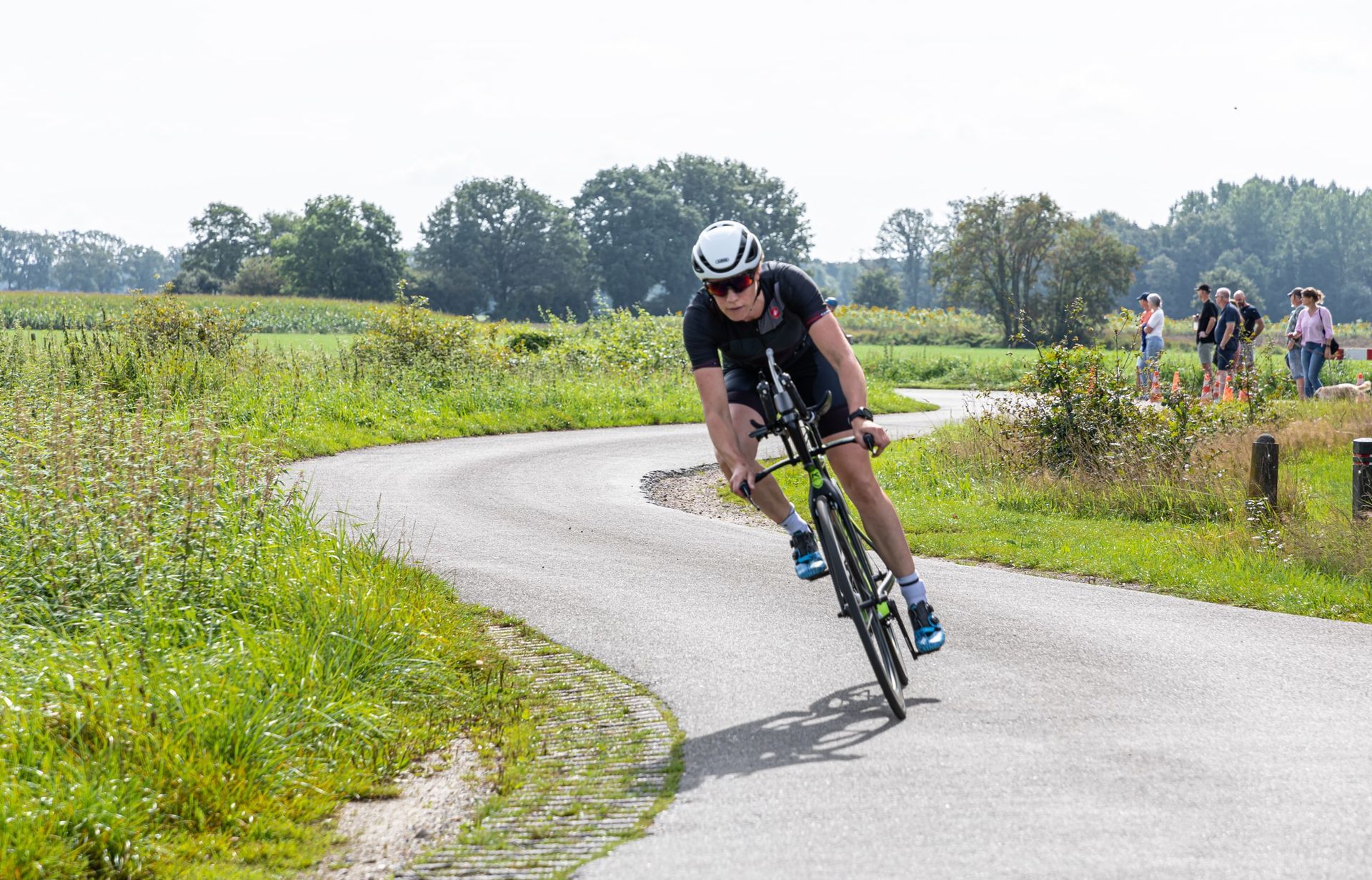 Een man fietst over een bochtige weg.