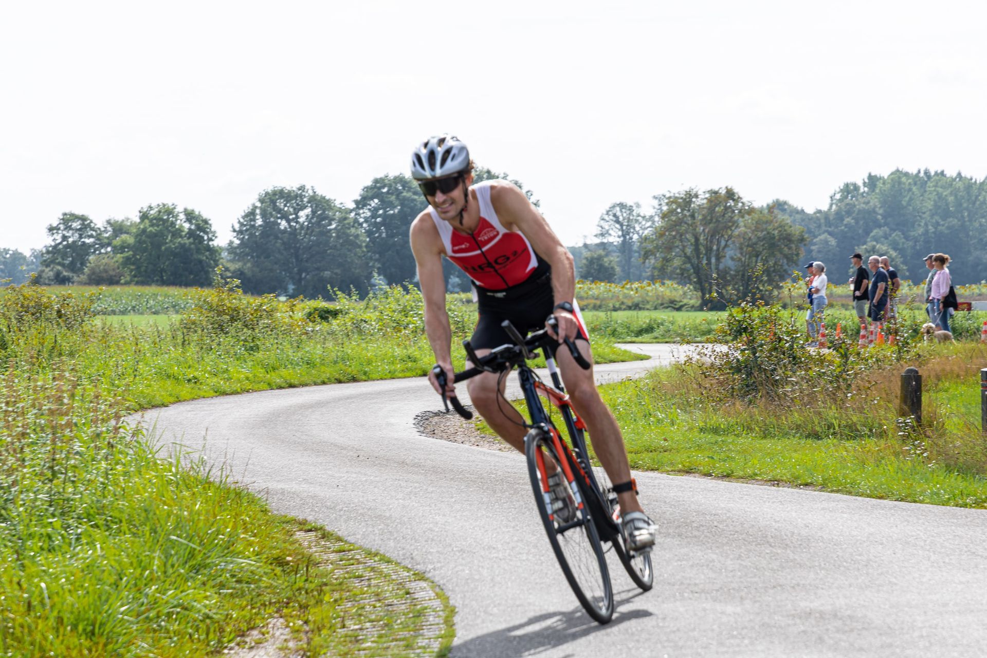 Een man fietst over een bochtige weg.