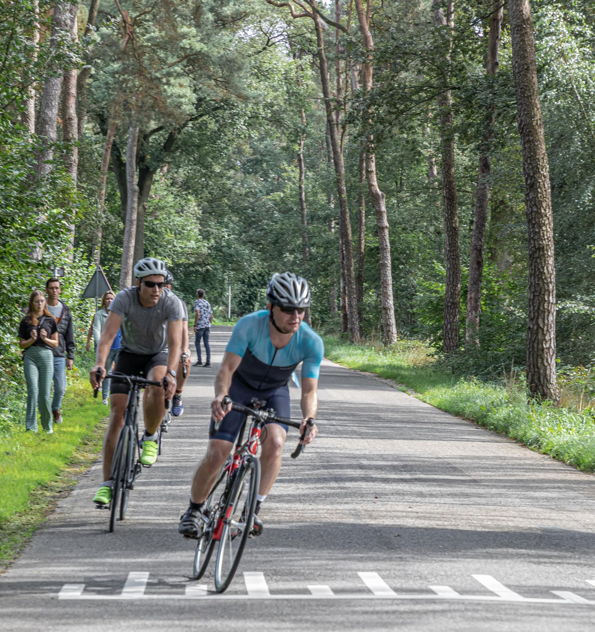 Een groep mensen fietst over een weg.