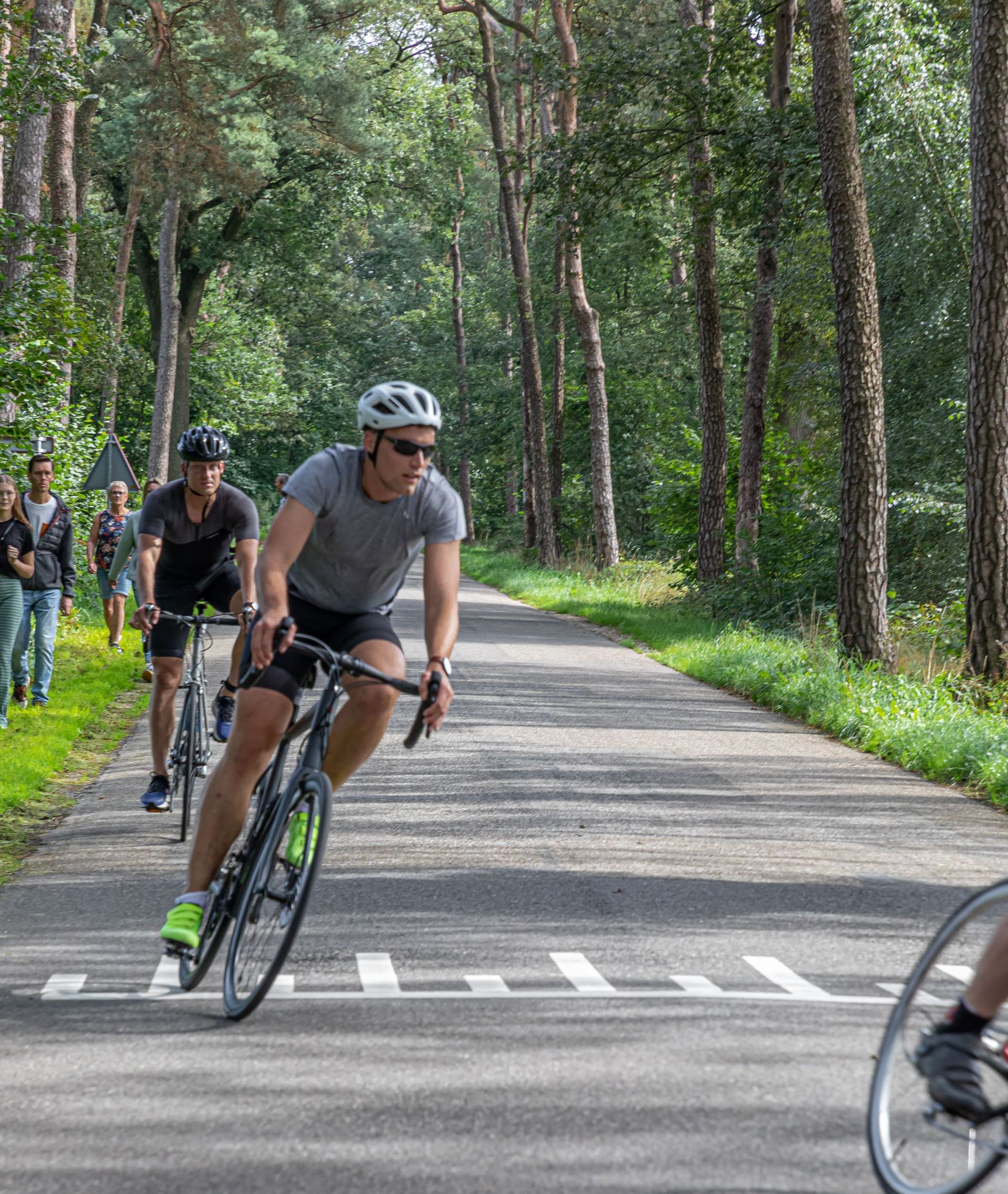 Een groep mensen fietst over een weg.