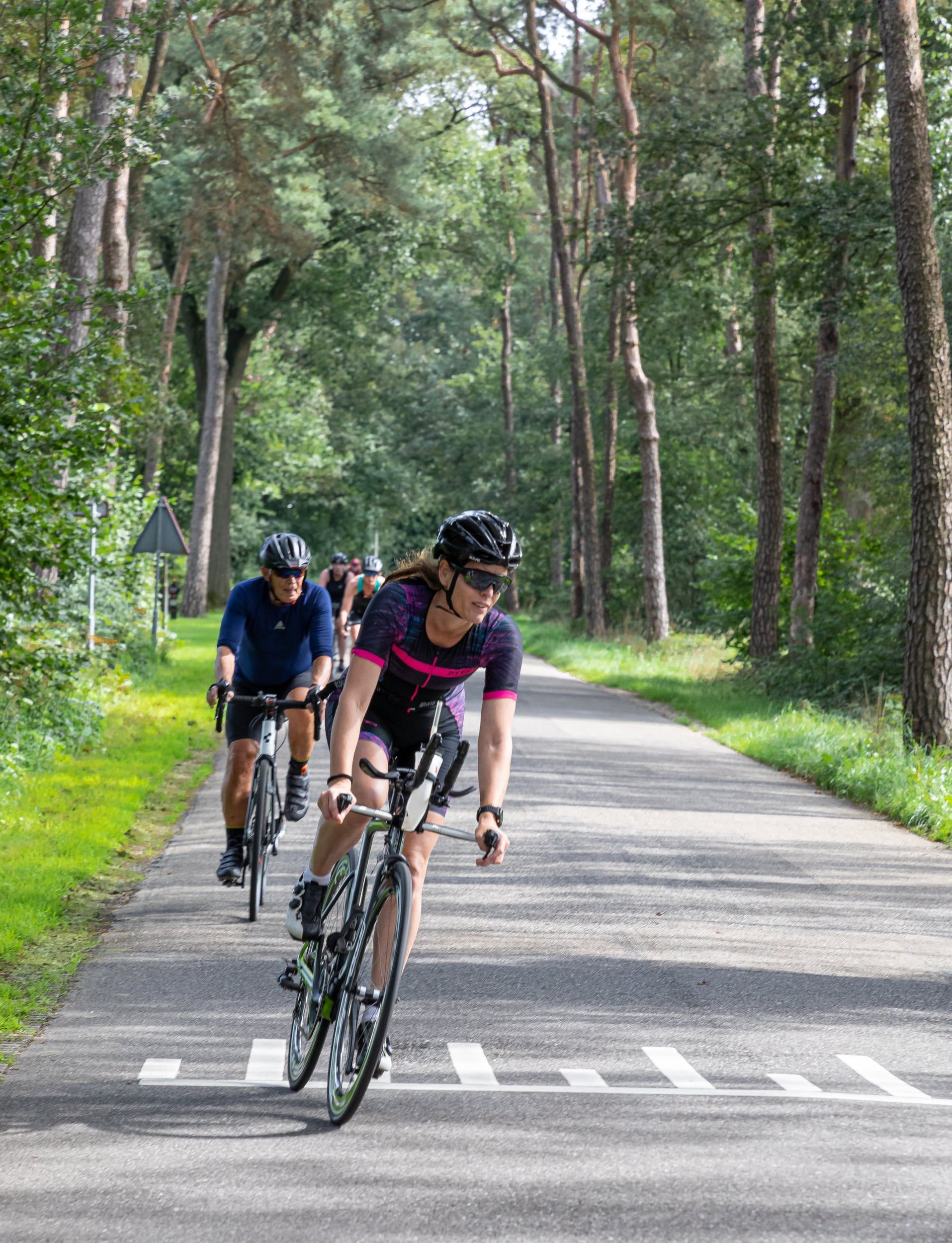 Een groep mensen fietst over een weg.