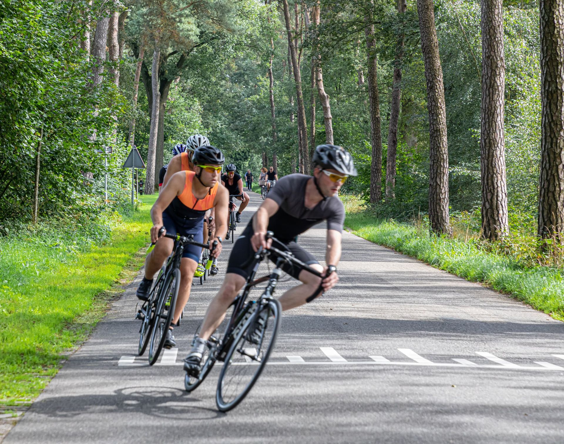 Een groep mensen fietst over een weg.