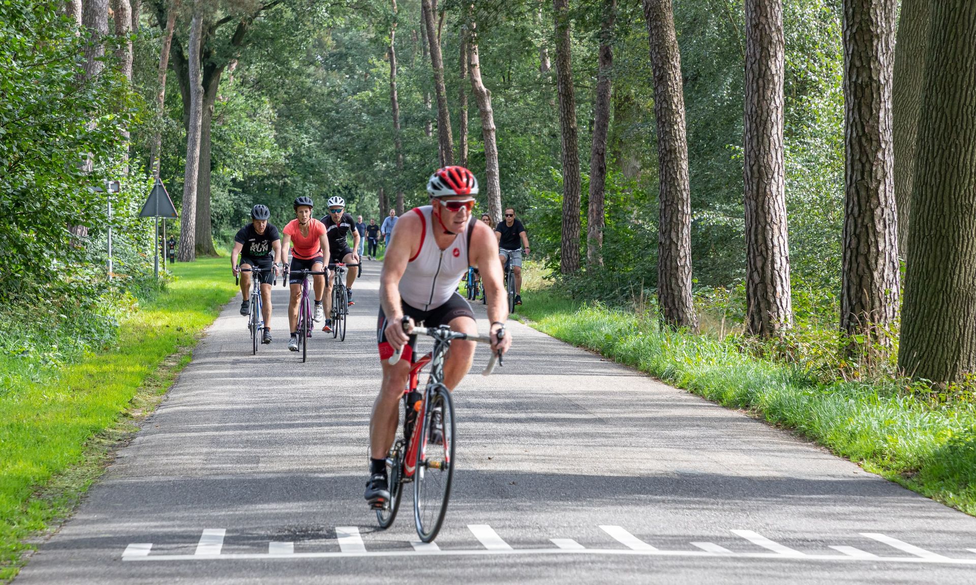 Een groep mensen fietst over een weg.