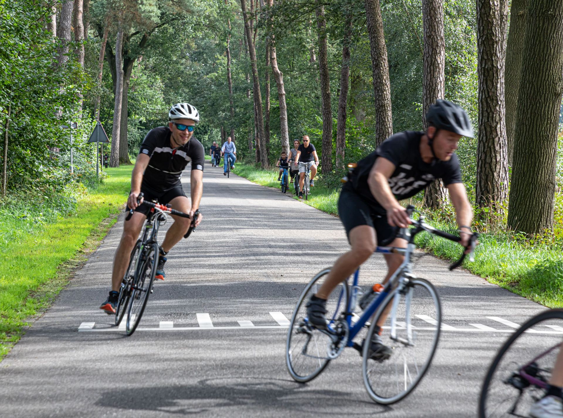 Een groep mensen fietst over een weg.