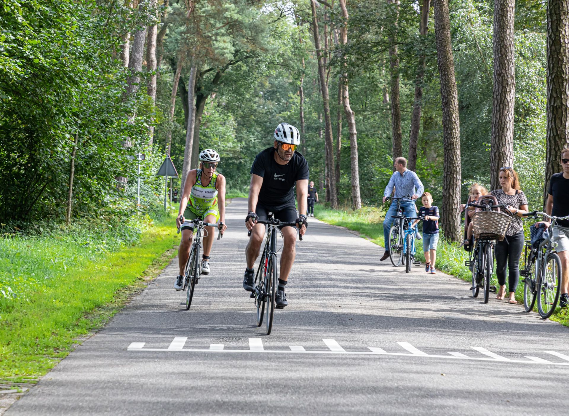 Een groep mensen fietst over een weg.