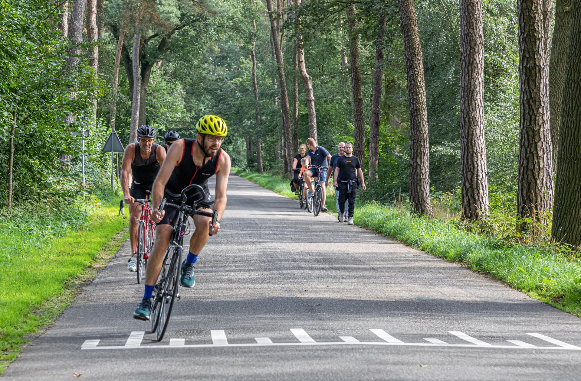 Een groep mensen fietst over een weg.