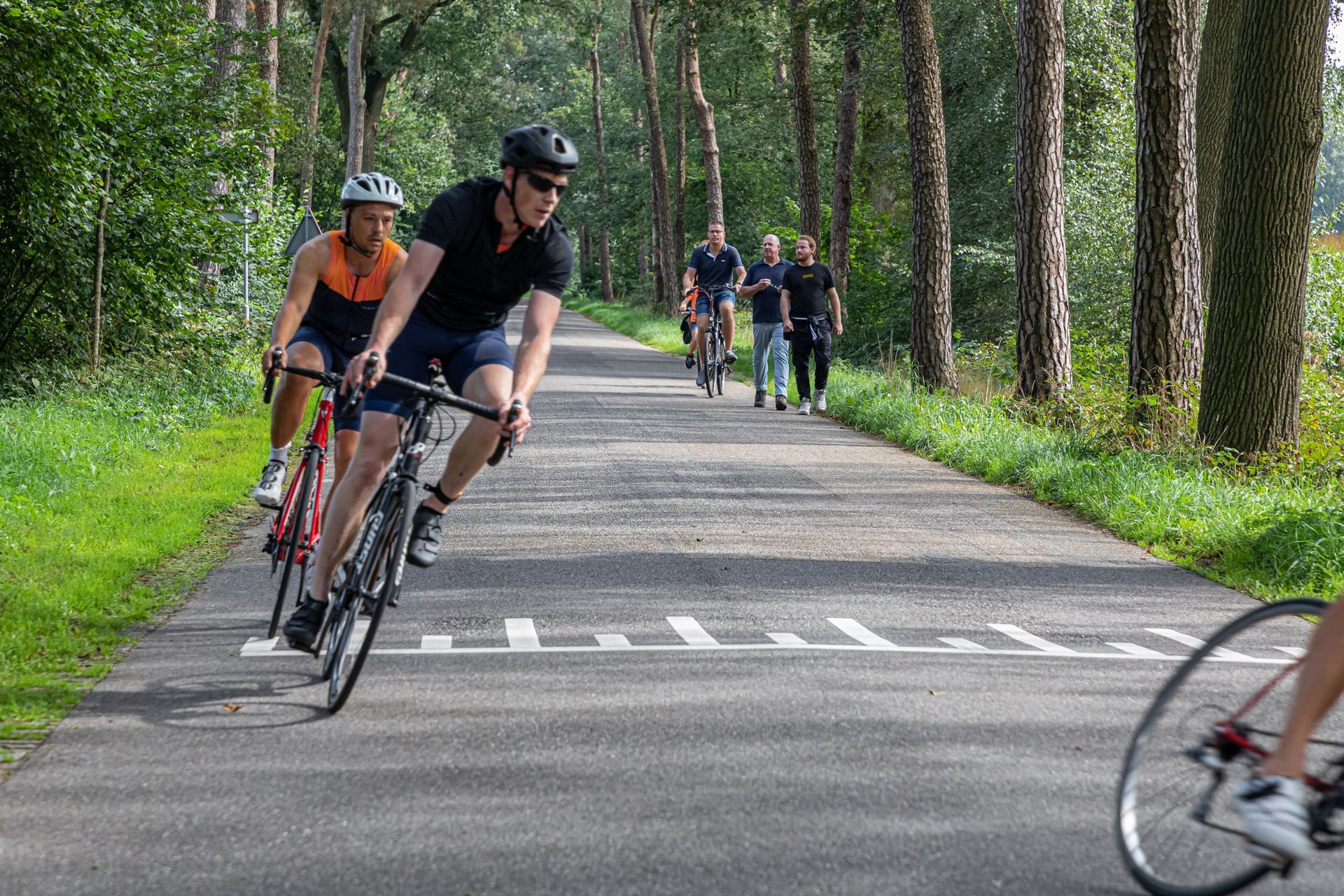 Een groep mensen fietst over een weg.