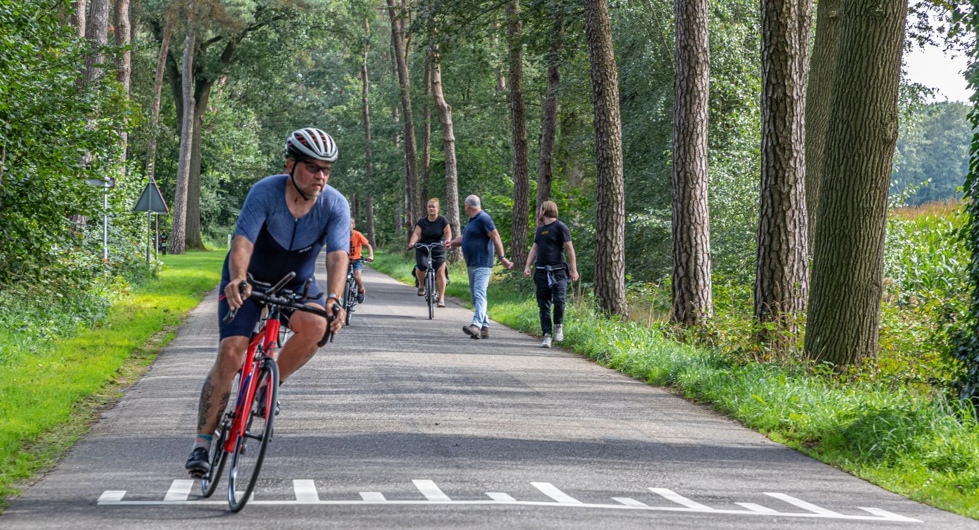 Een groep mensen fietst over een weg.