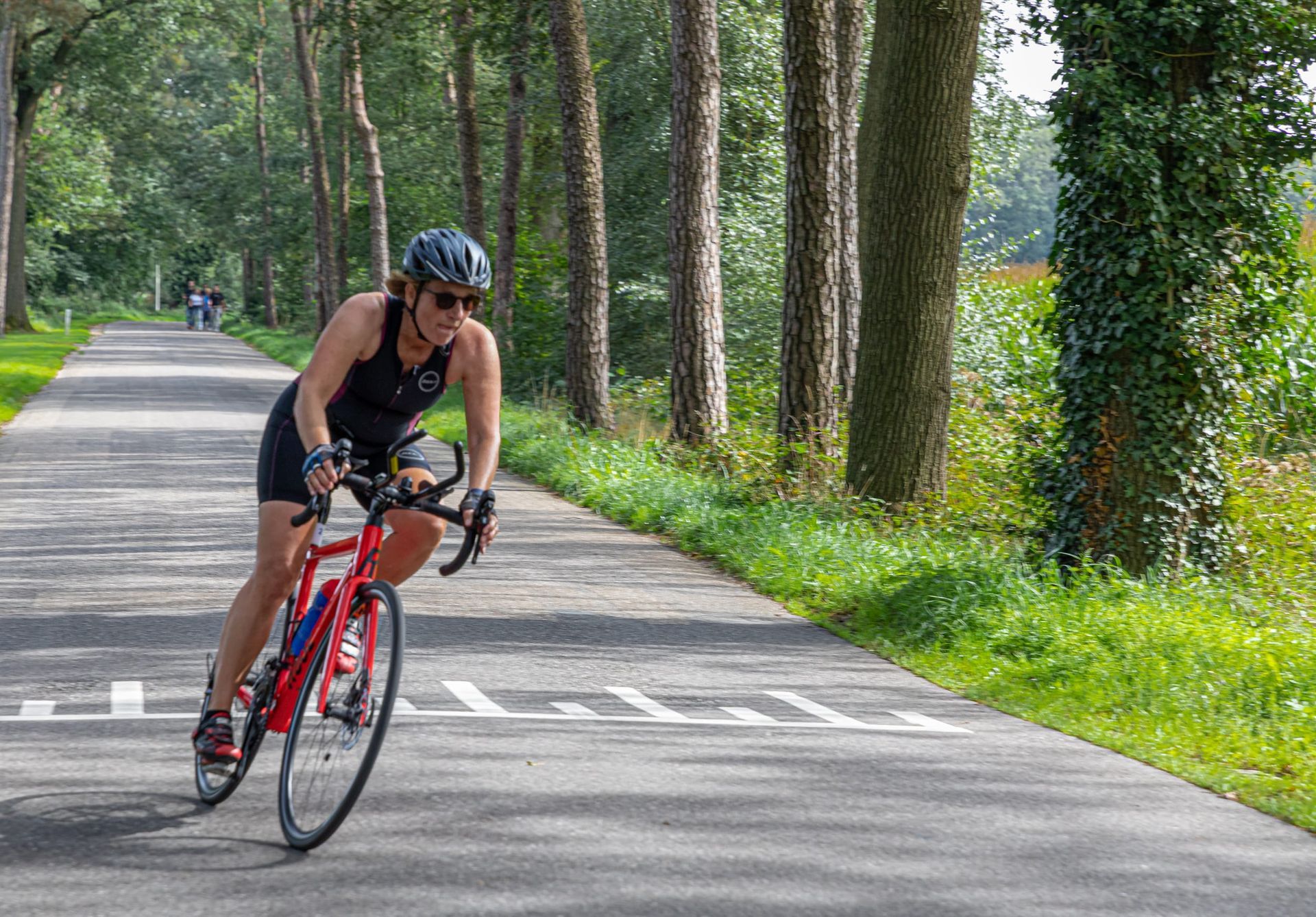 Een vrouw fietst over een weg.