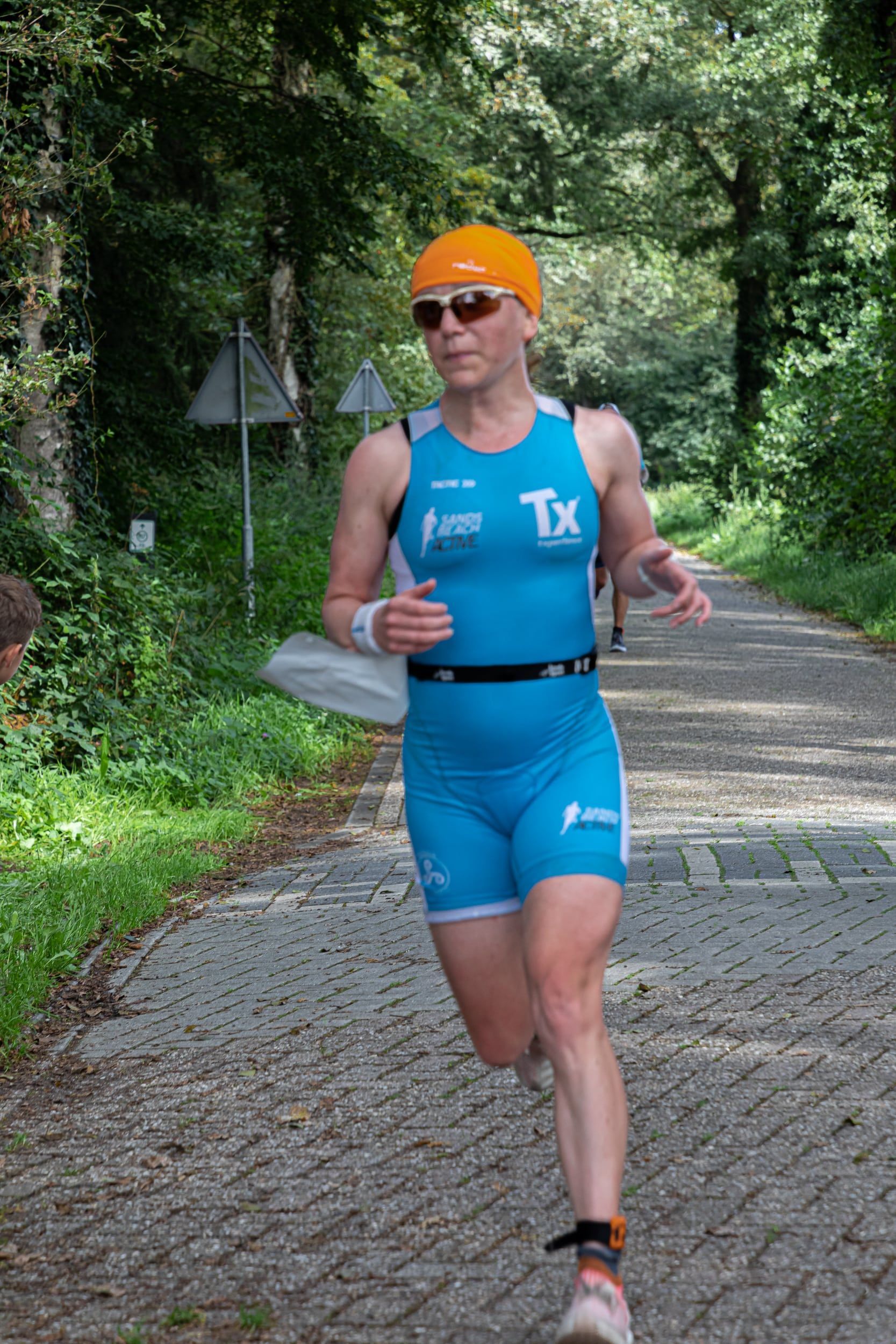 Een vrouw in een blauw tanktopje met de letter tx erop