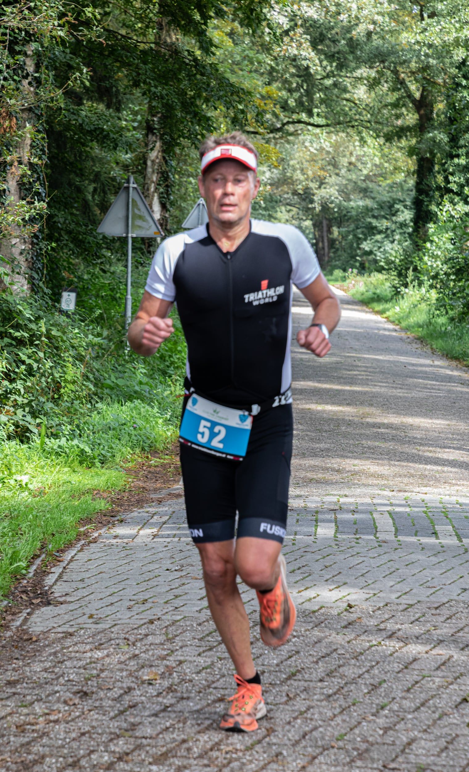 Een man rent over een stenen weg.