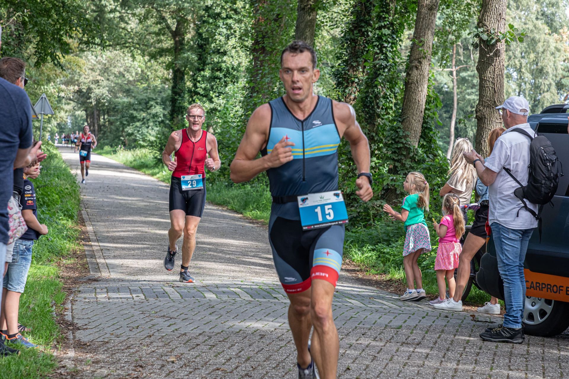 Een man rent over een stenen weg tijdens een triatlon.