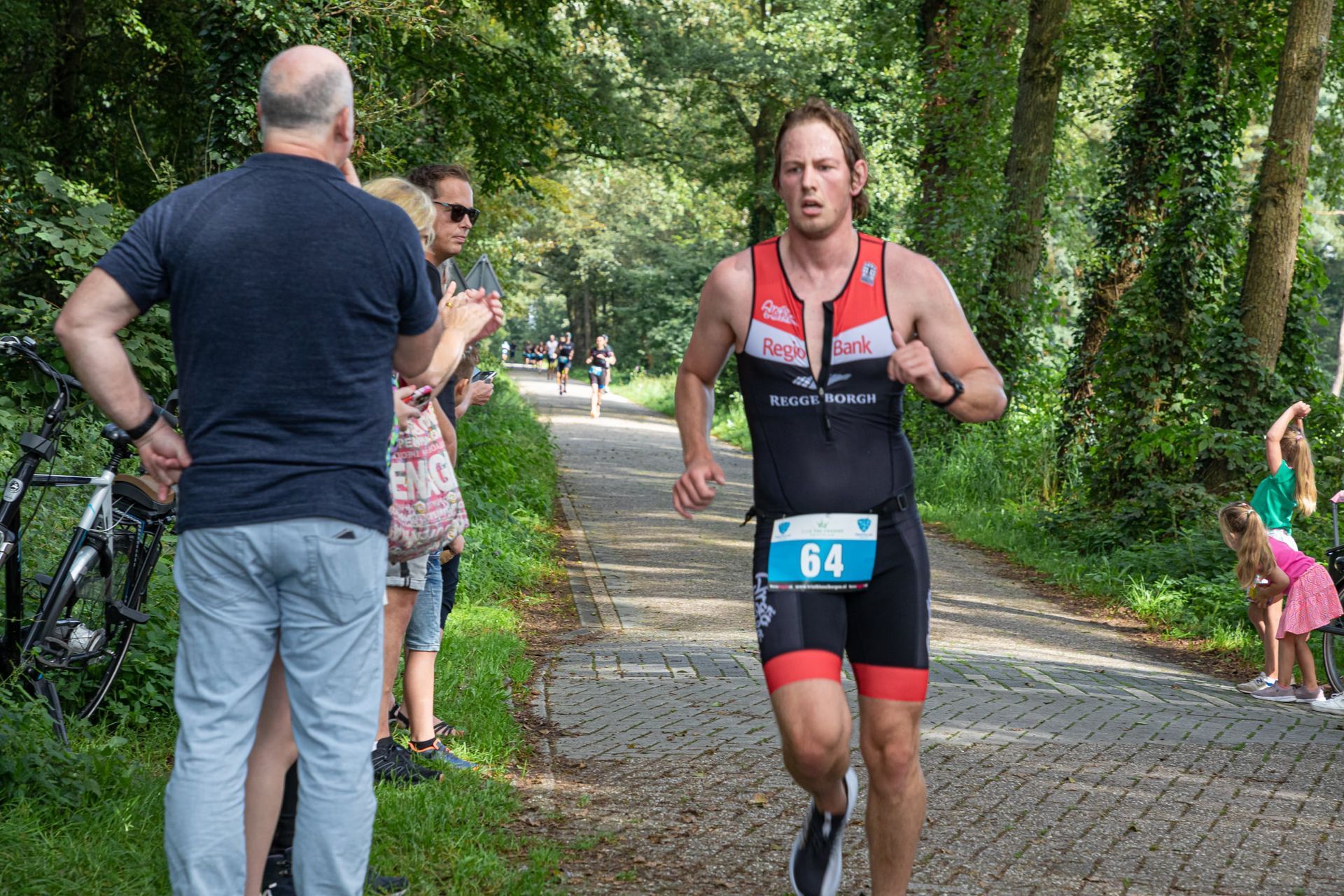 Een man rent over de weg met nummer 84 op zijn startnummer.