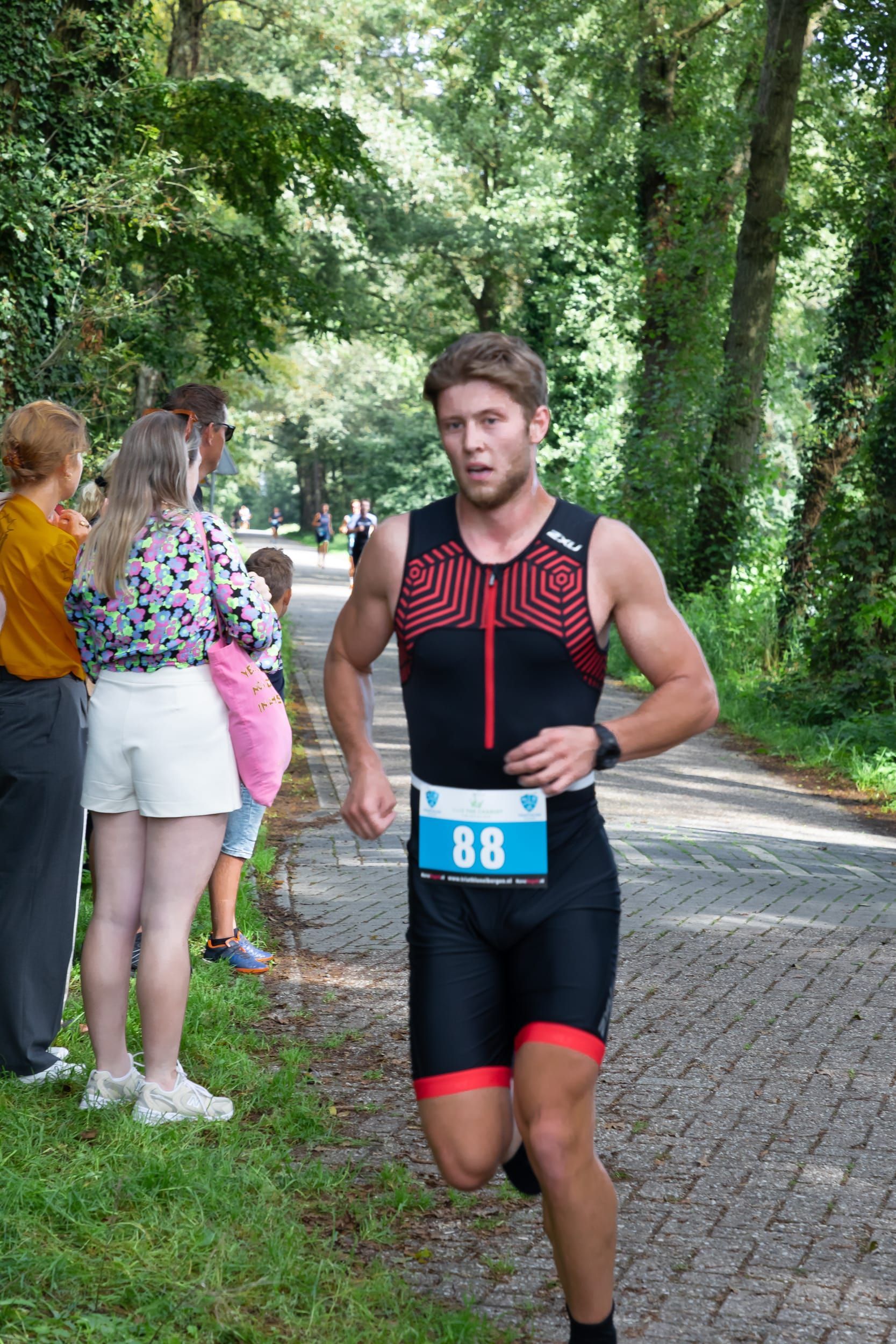 Een man rent over de weg tijdens een triatlon.