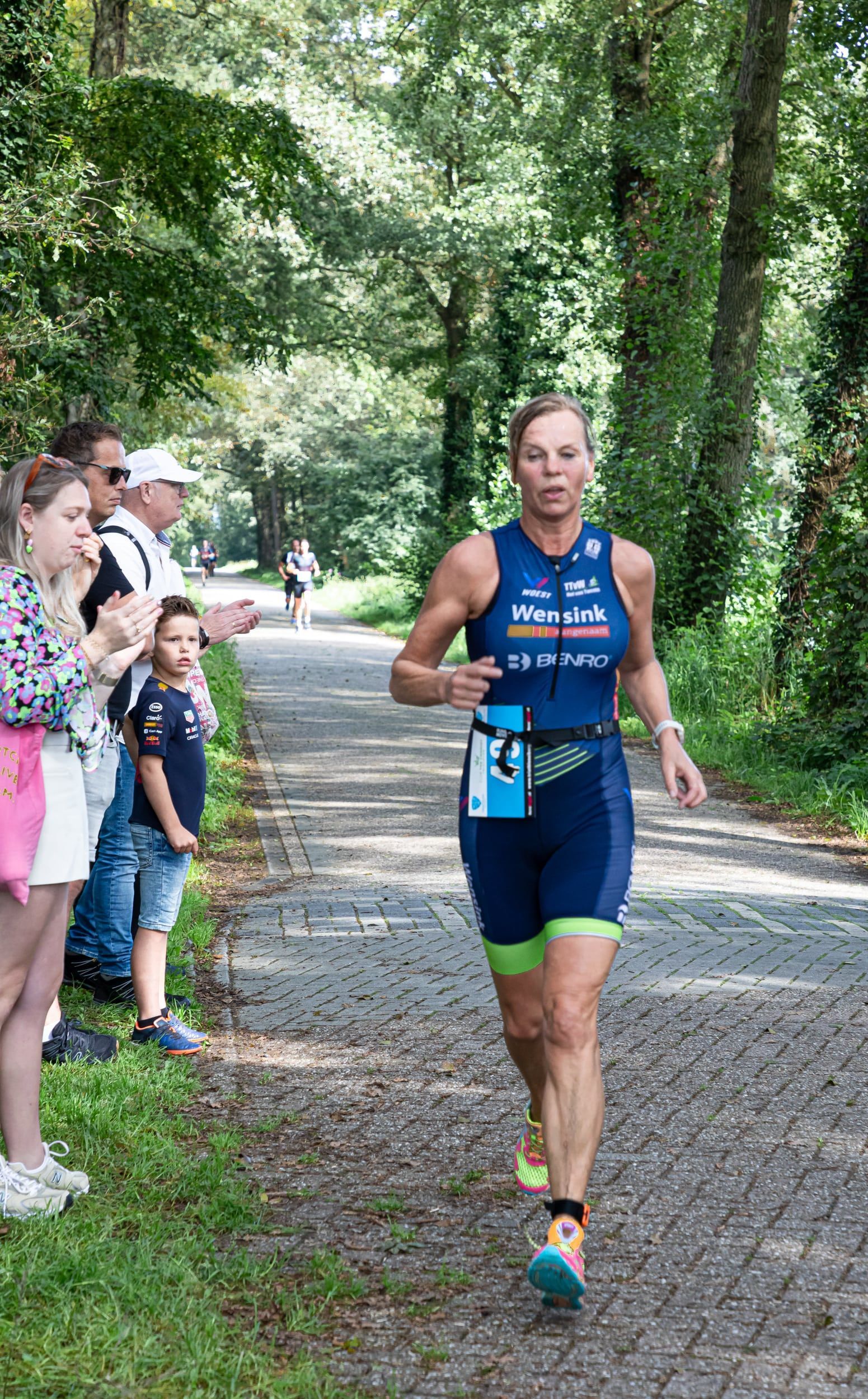 Een vrouw rent over de weg tijdens een triatlon.