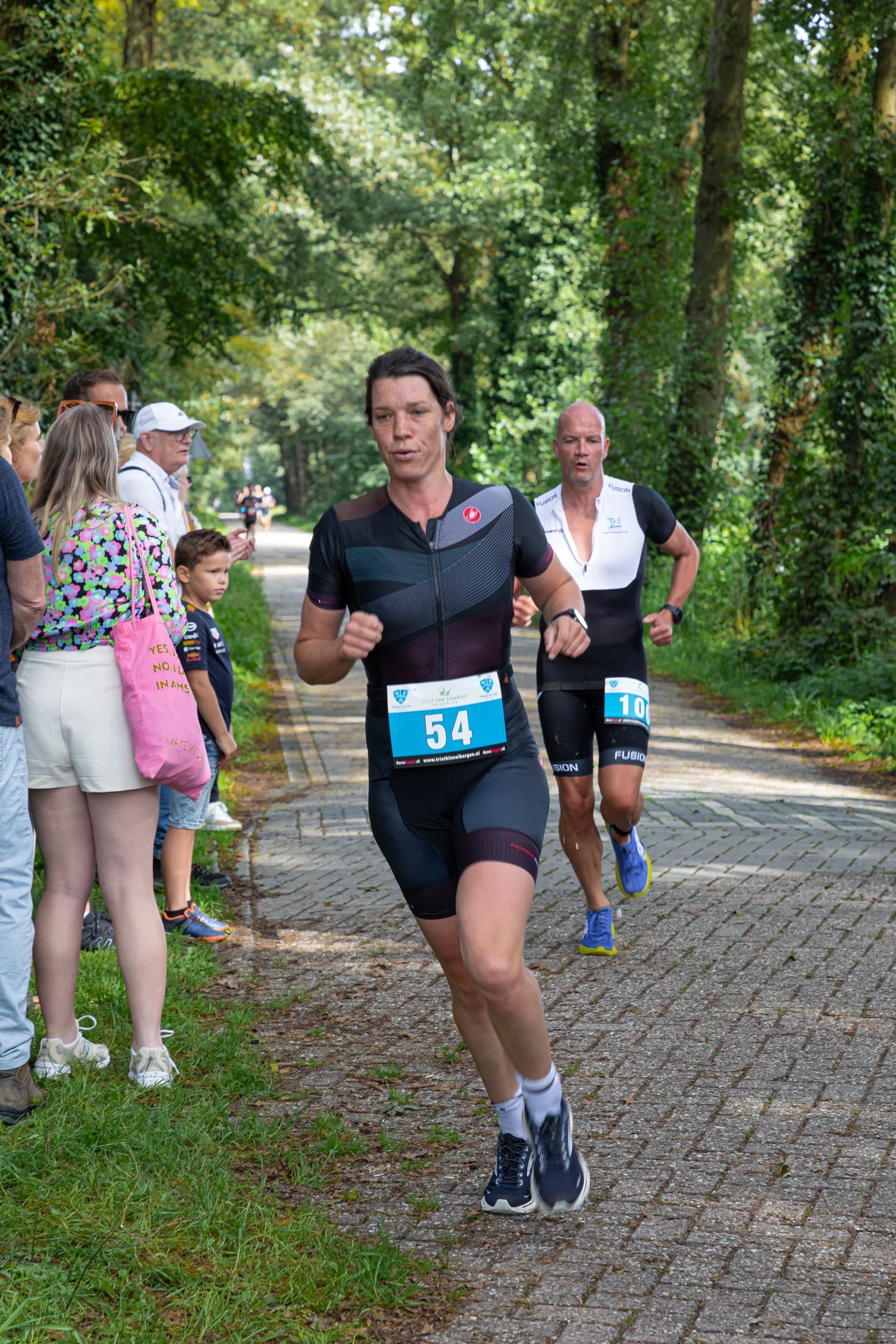 Een groep mensen rent een marathon op een onverharde weg.