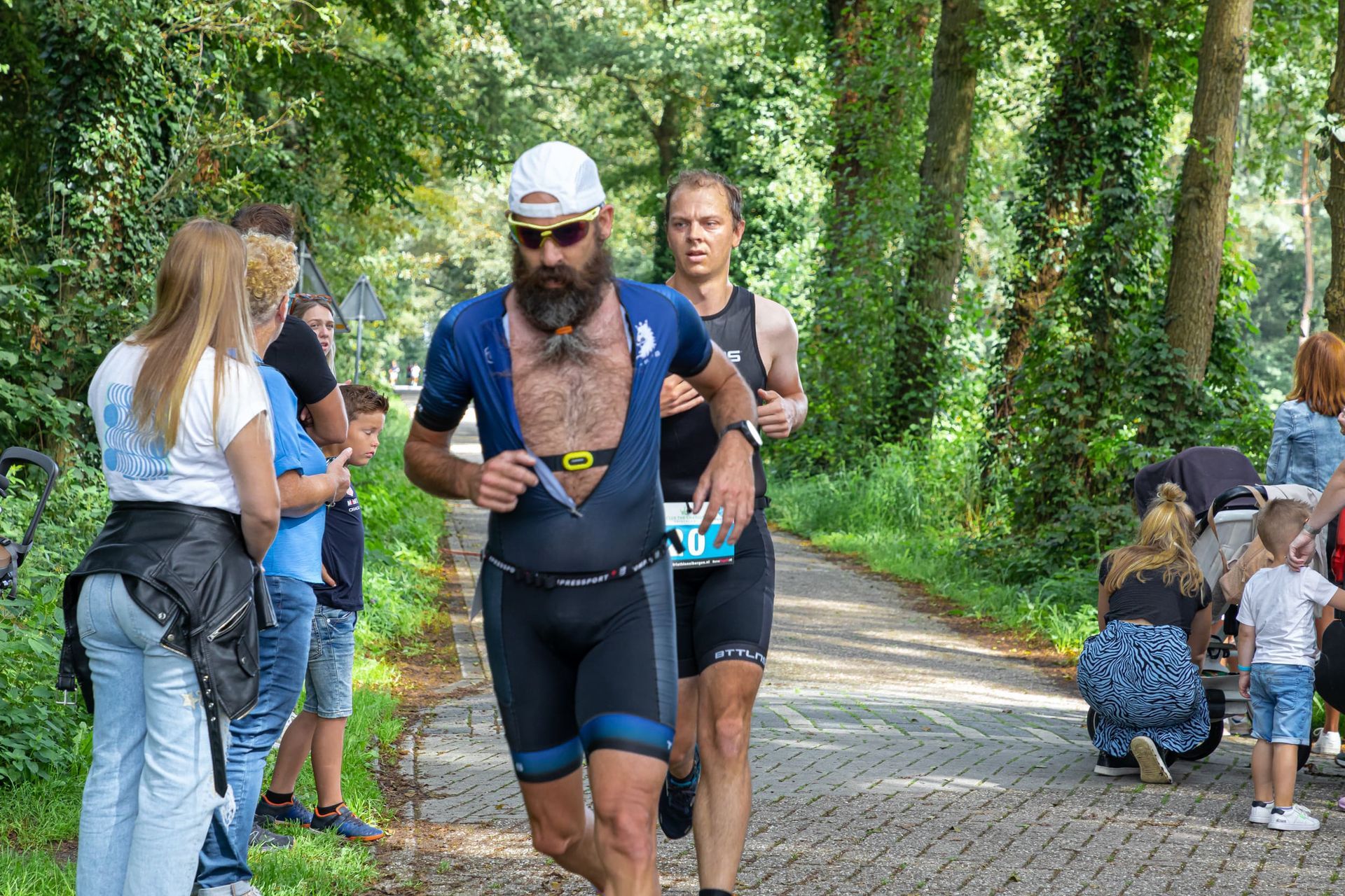 Een man met een baard rent over de weg.