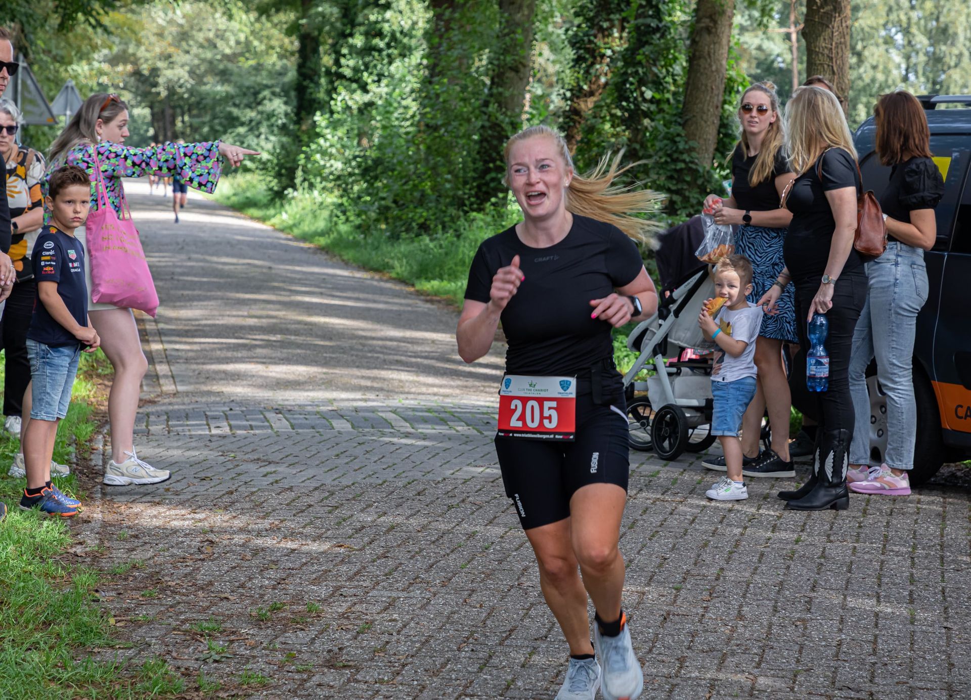 Een vrouw rent een marathon op een stenen weg.