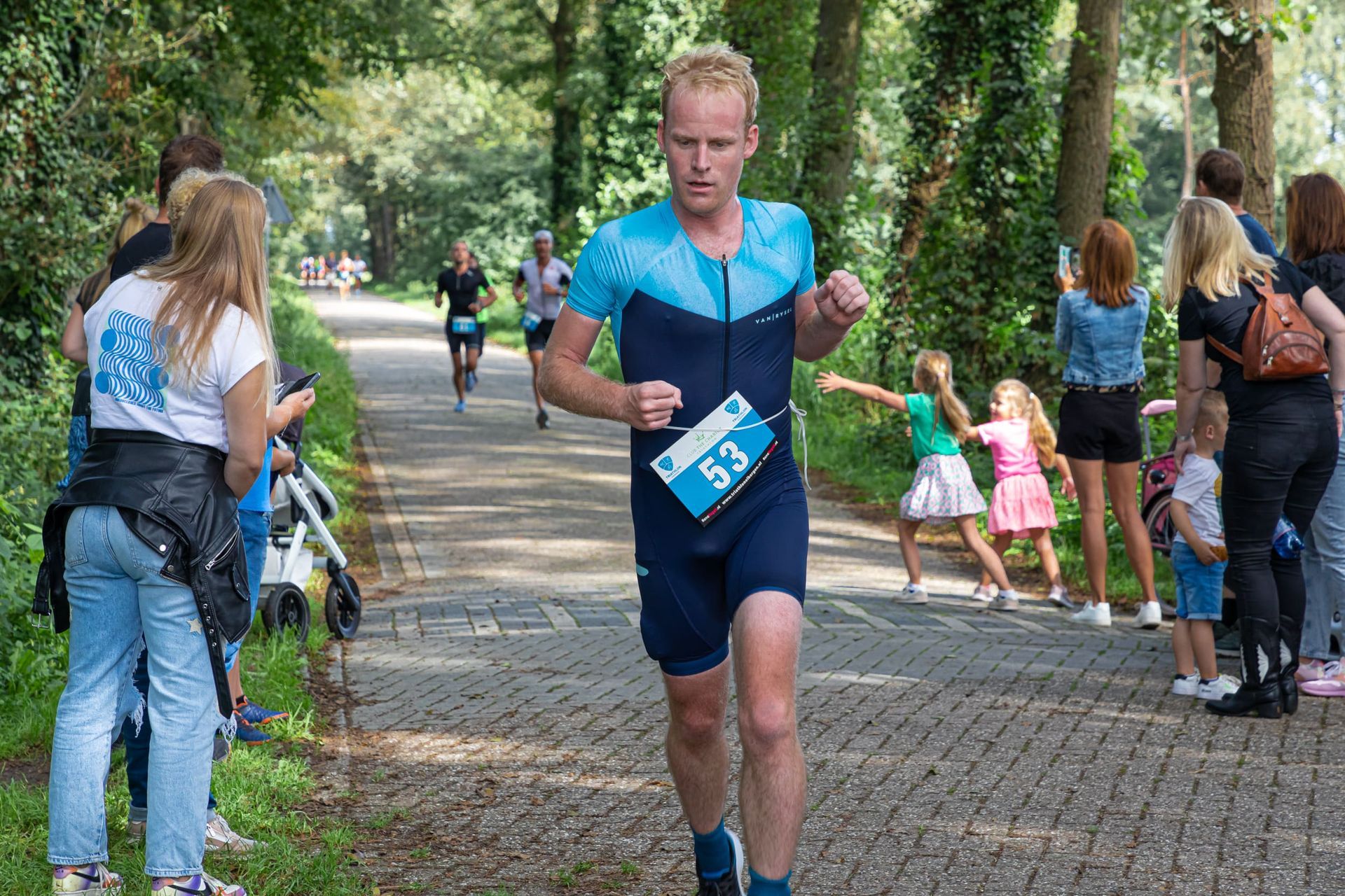 Een man doet mee aan een race met een startnummer op zijn shirt.