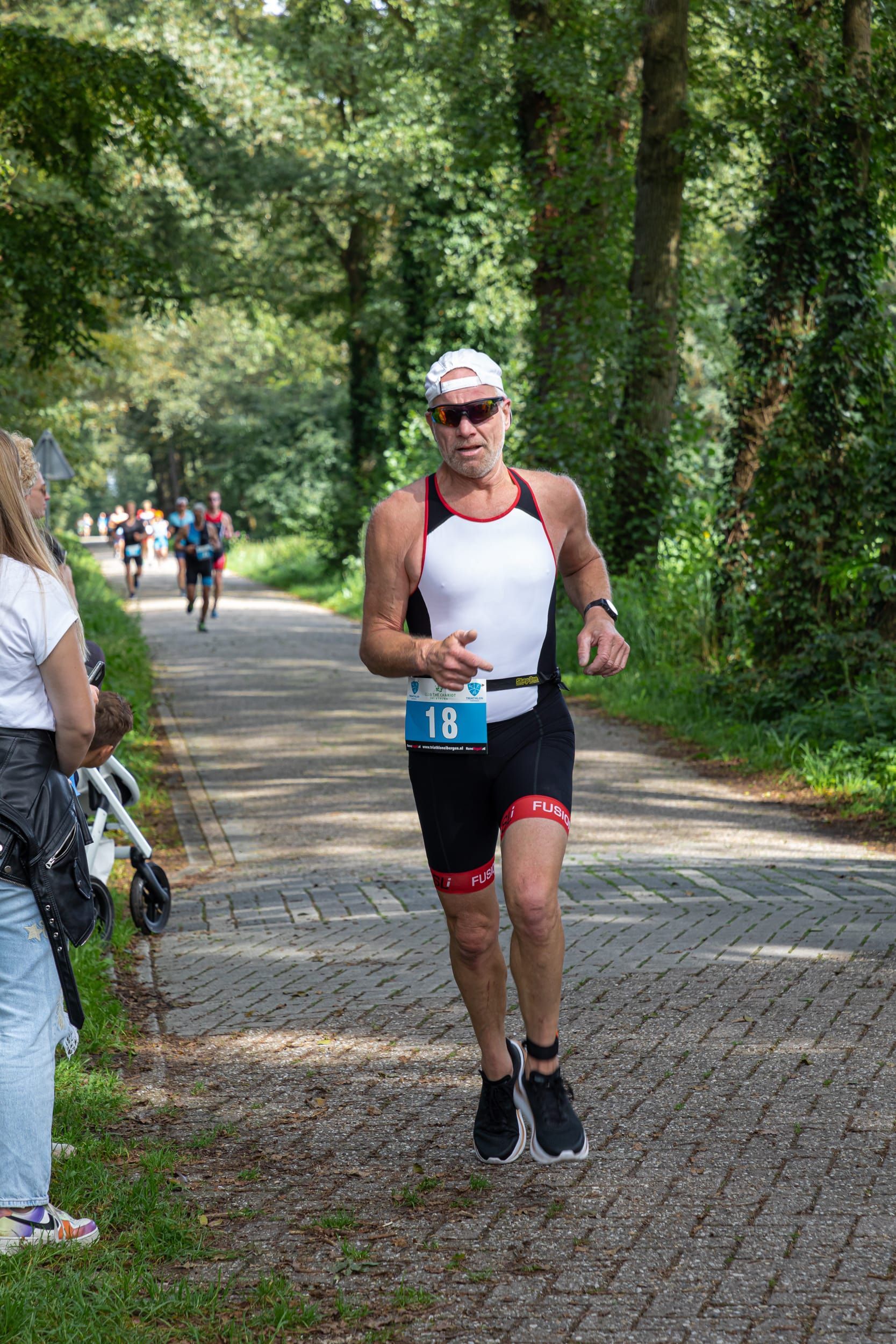 Een man rent over de weg tijdens een triatlon.
