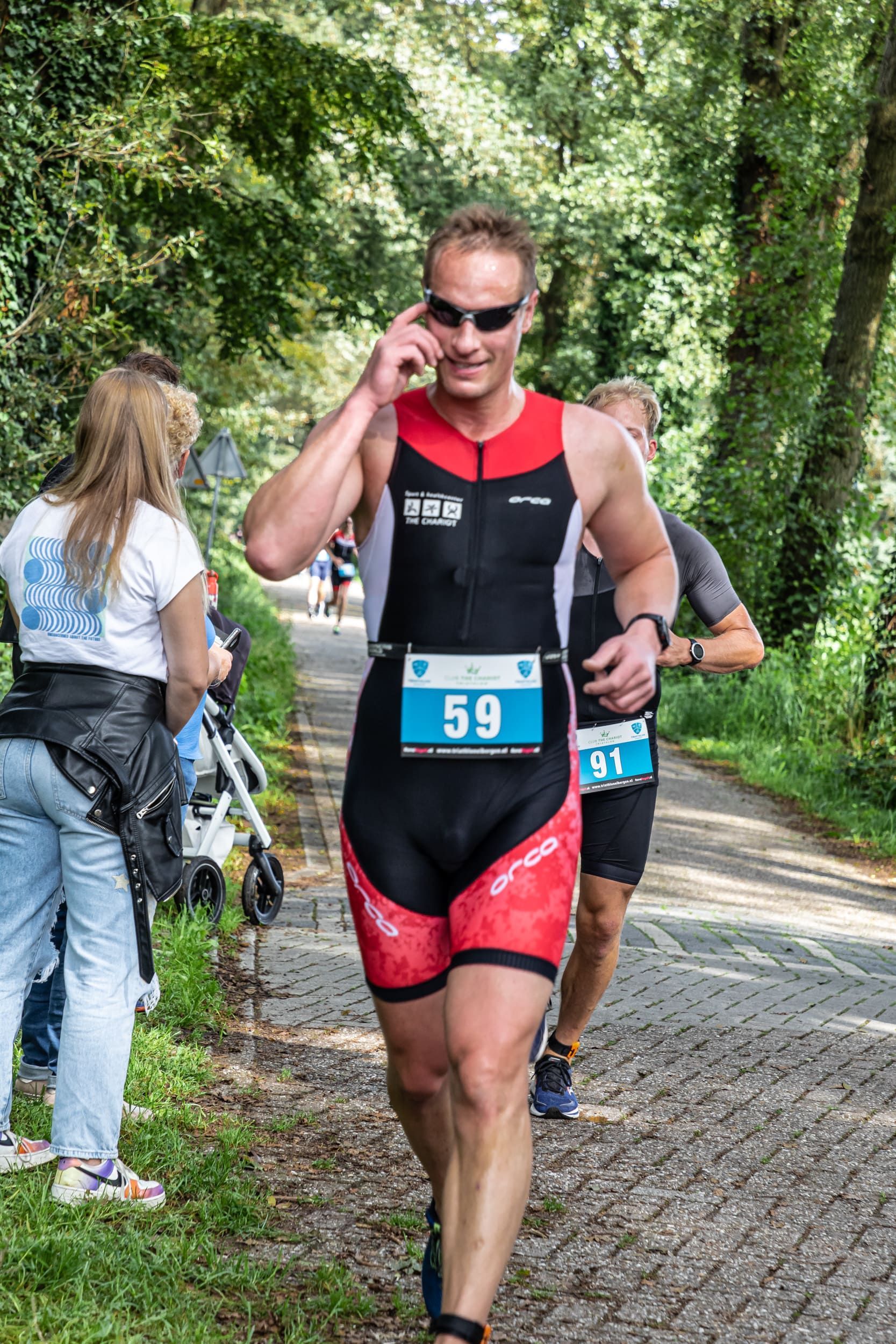 Een man rent een triatlon en belt via een mobiele telefoon.
