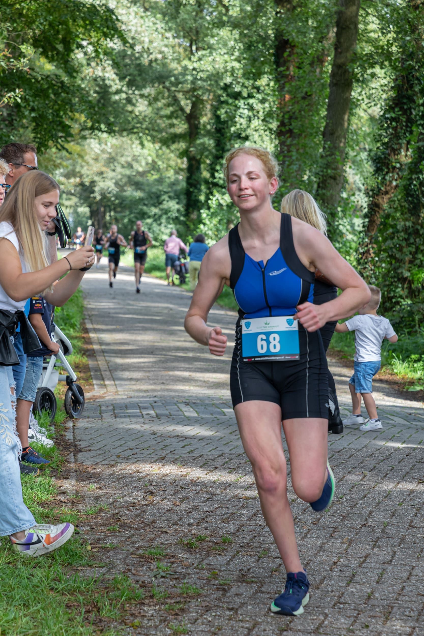 Een vrouw rent een marathon in een park.