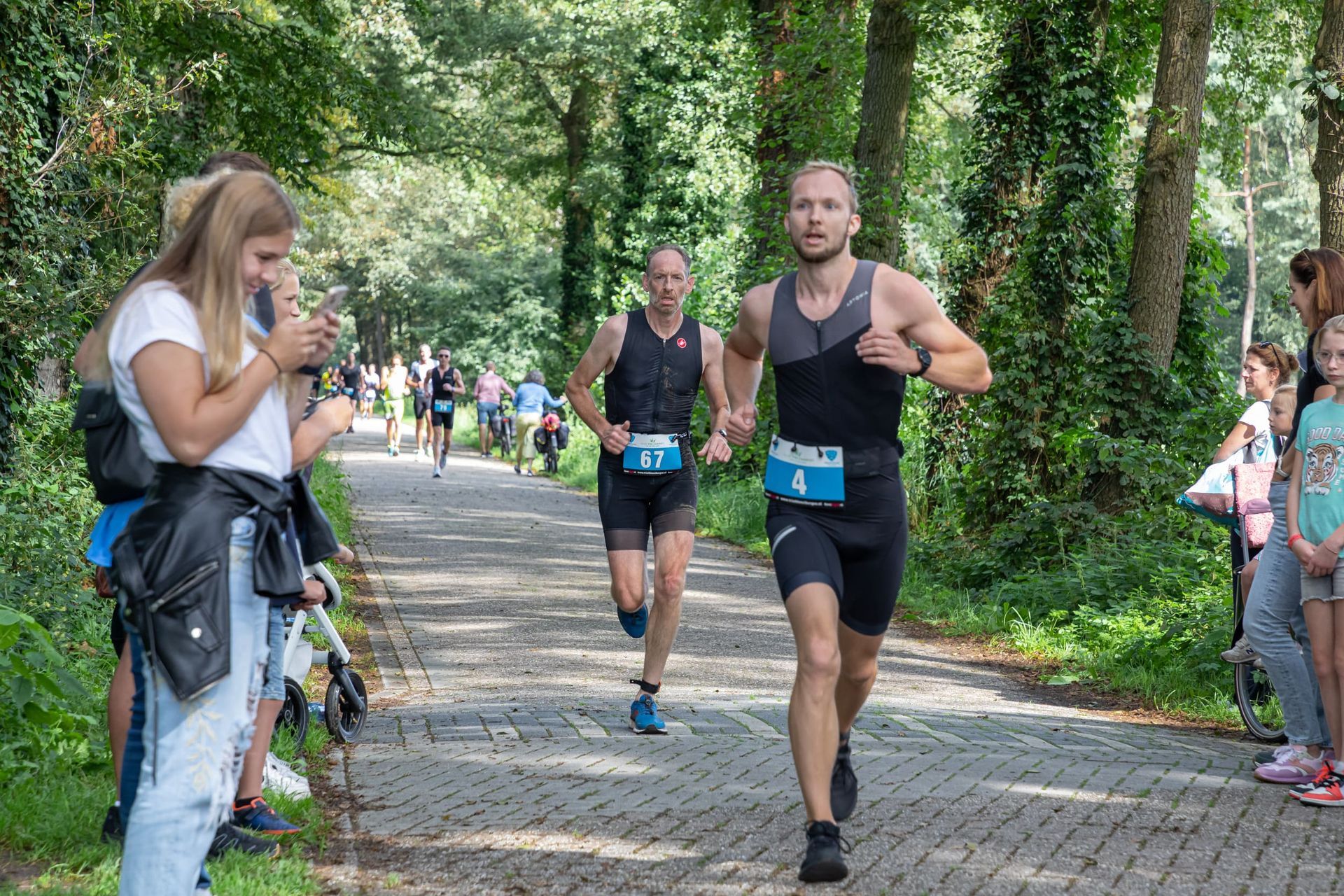 Een groep mannen rent een marathon op een stenen weg.