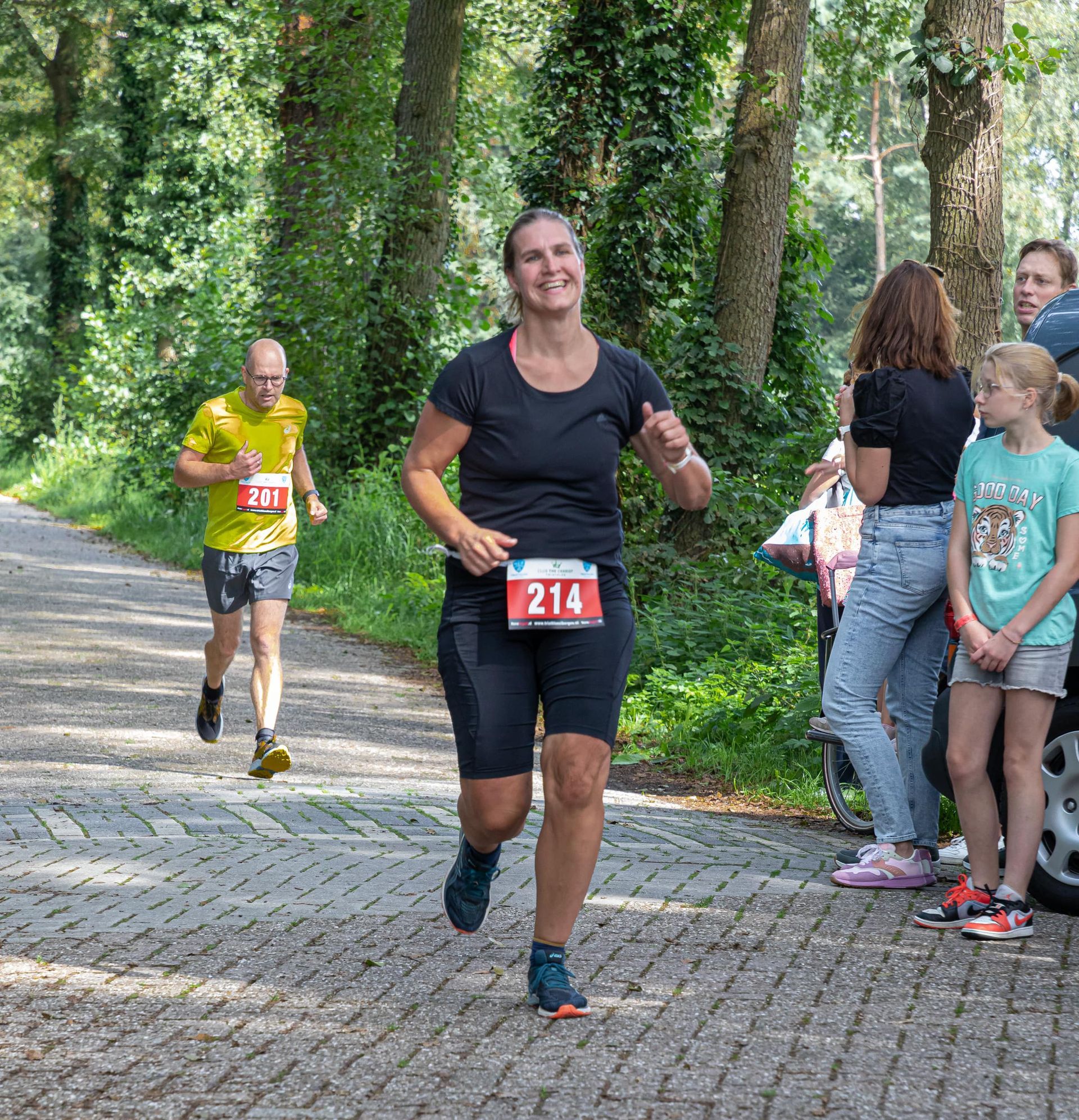 Een vrouw rent een marathon op een stenen weg.
