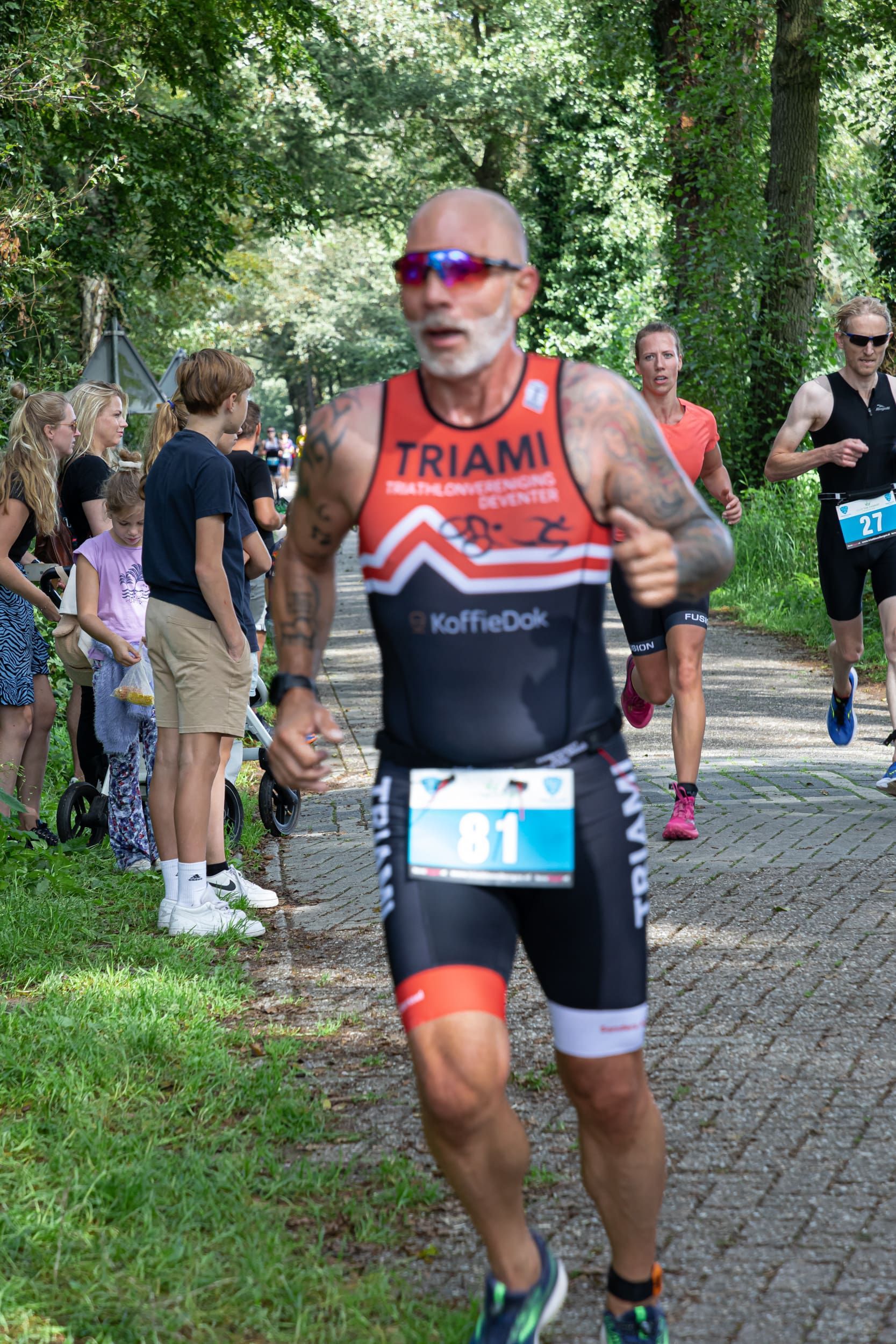 Een man met een baard doet mee aan een triatlon.