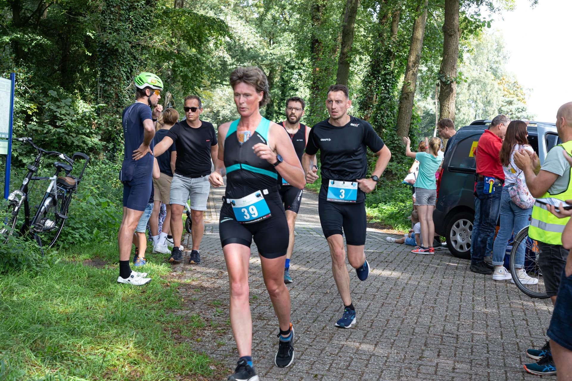 Een groep mensen rent een marathon op een geplaveide weg.