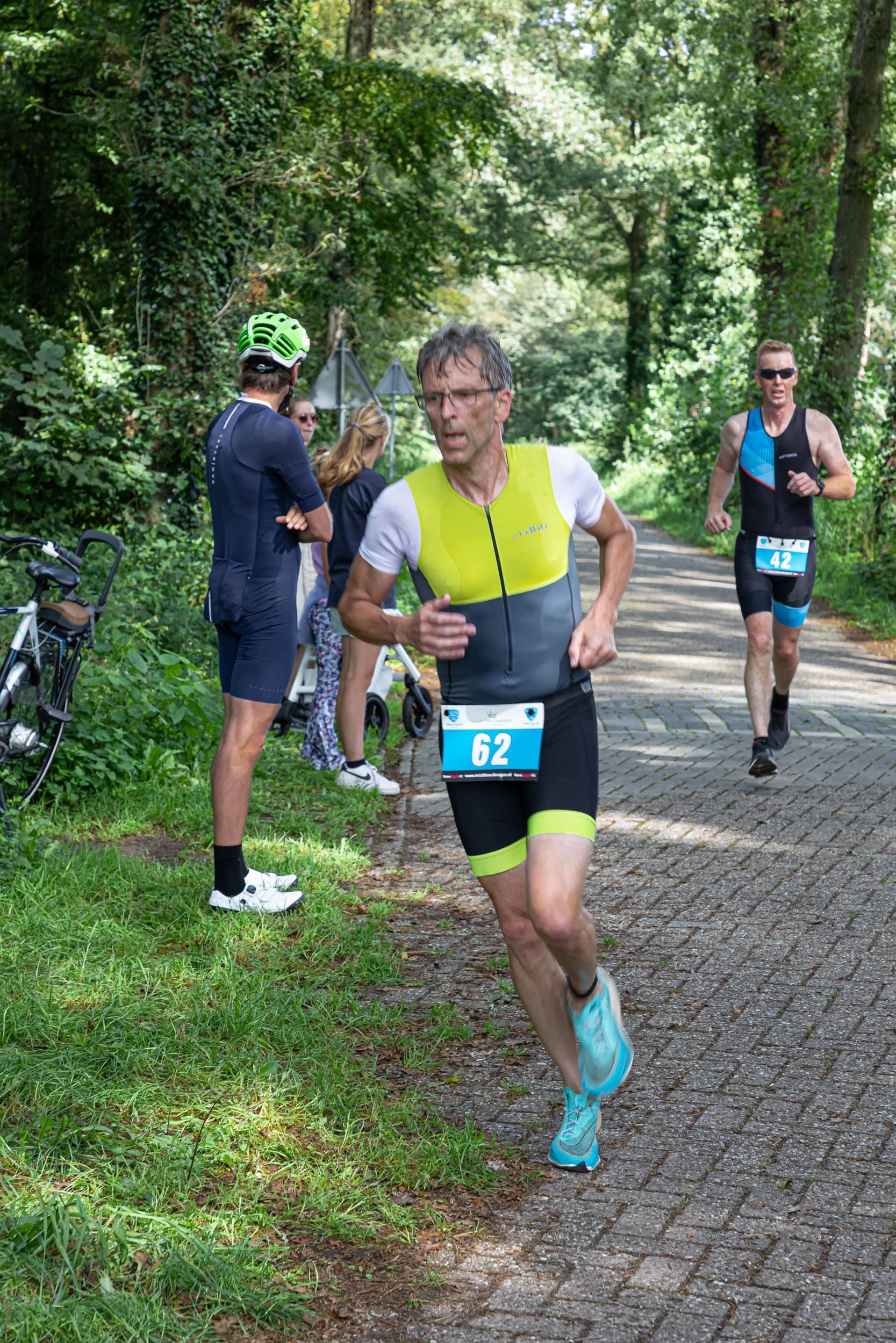 Een groep mannen rent een triatlon op een onverharde weg.