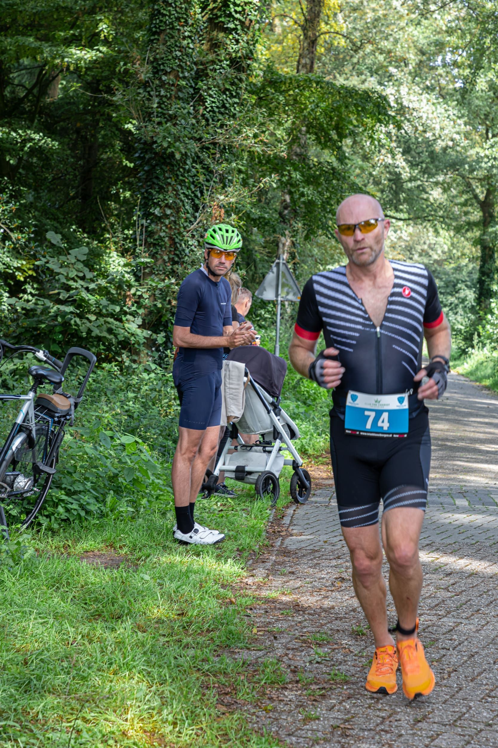 Een man rent over een onverharde weg in het bos.