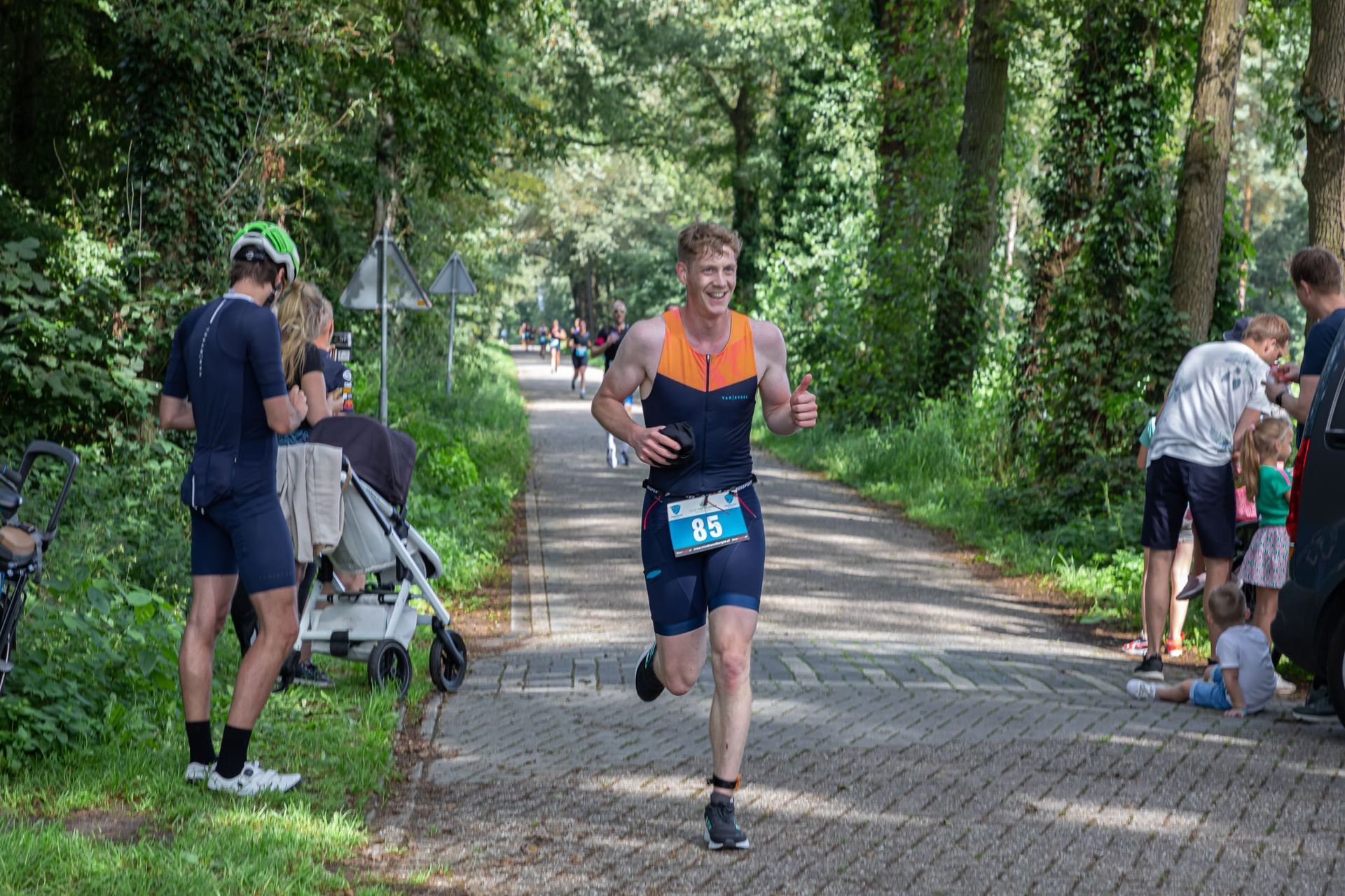 Een man rent over een stenen weg in het bos.