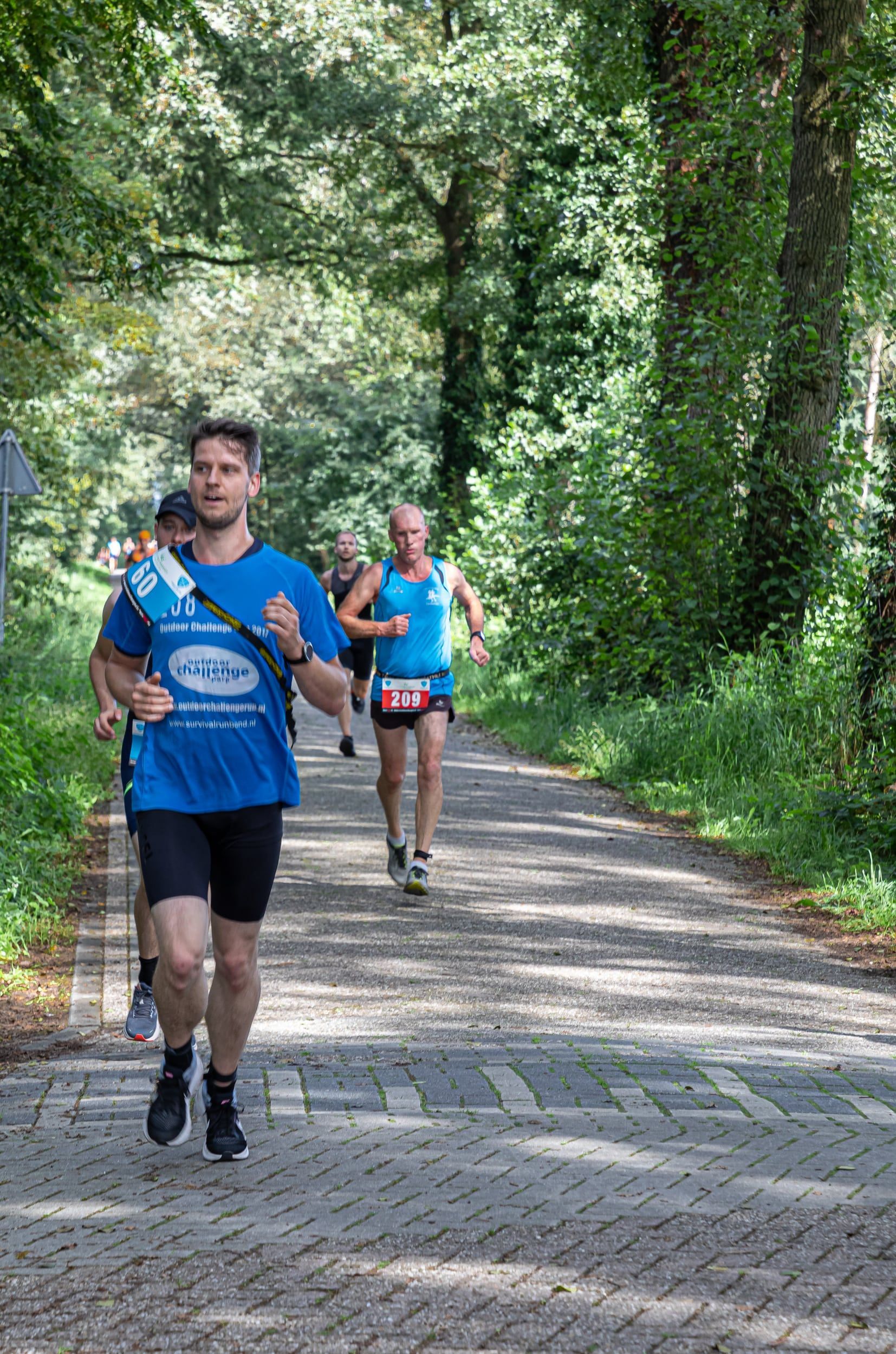 Een groep mensen rent over een onverharde weg.