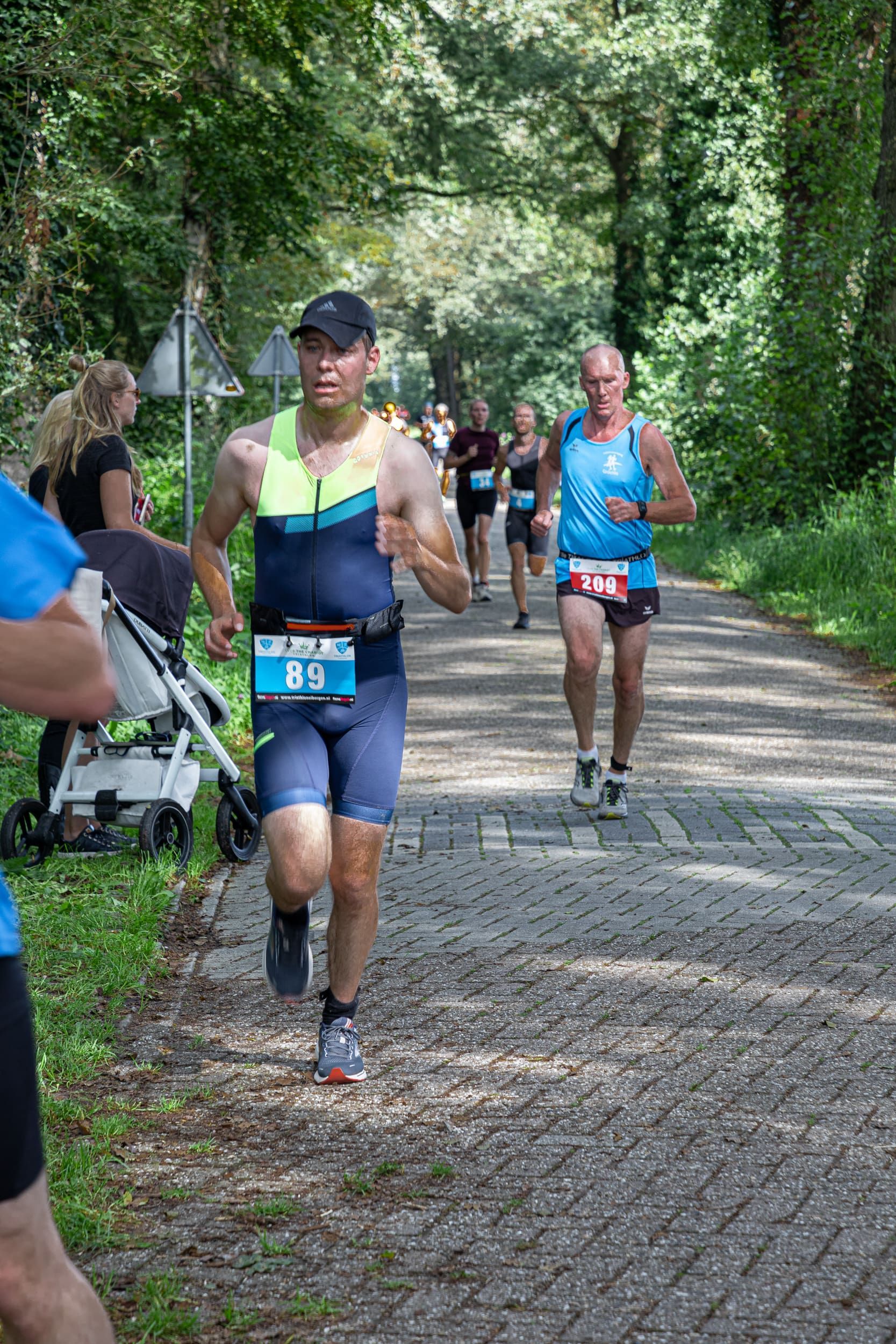 Een groep mannen rent over een geplaveide weg.