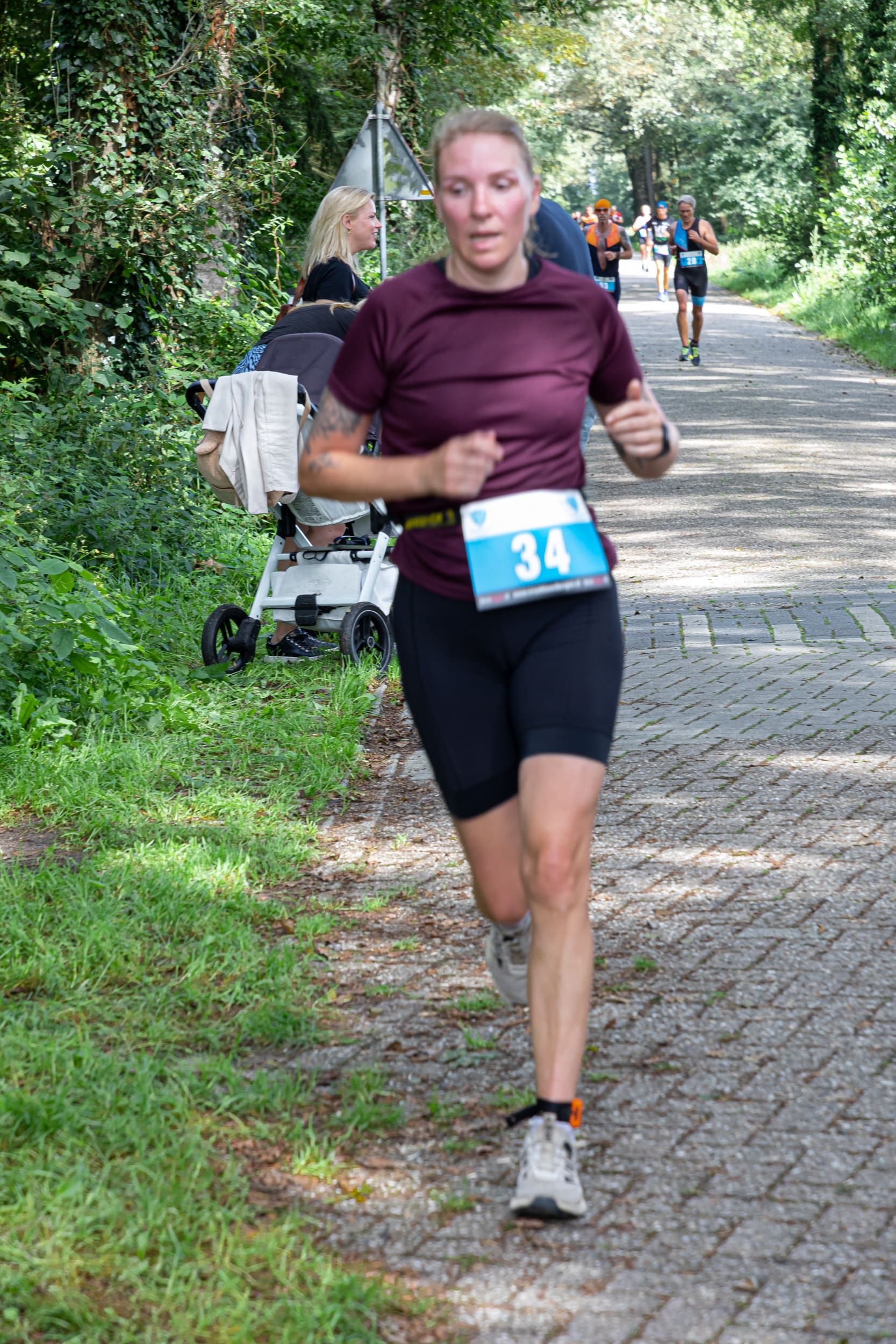 Een vrouw rent een marathon op een stenen weg.