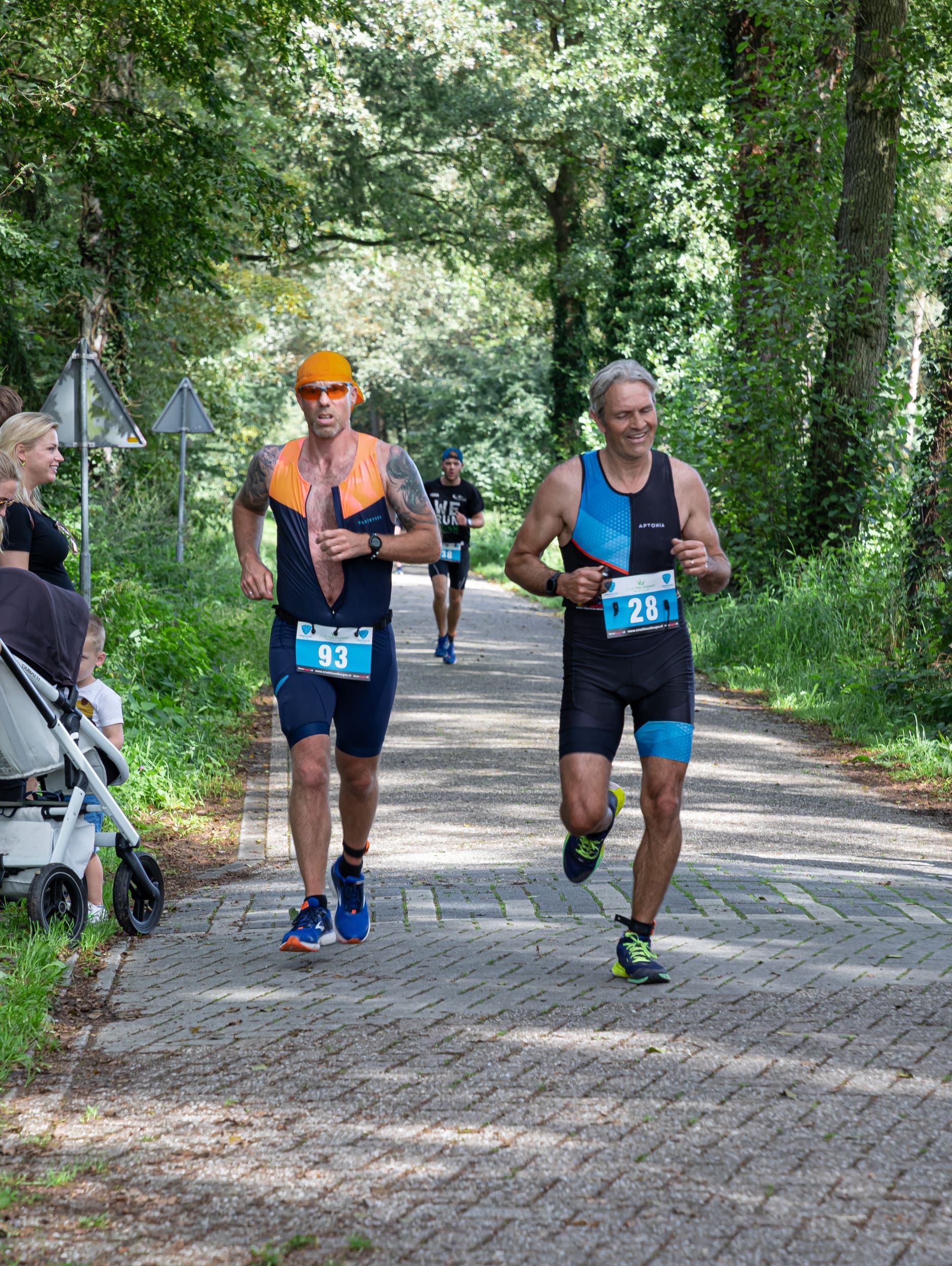 Een groep mannen rent over een stenen weg.