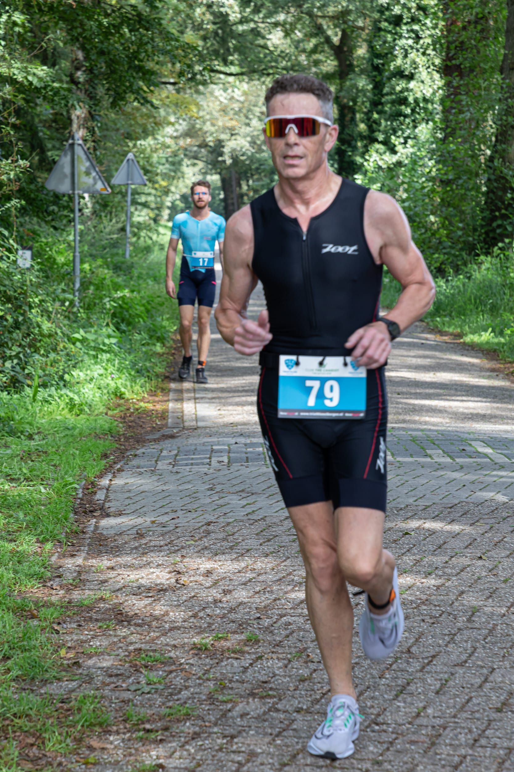 Een man rent een marathon op de weg.