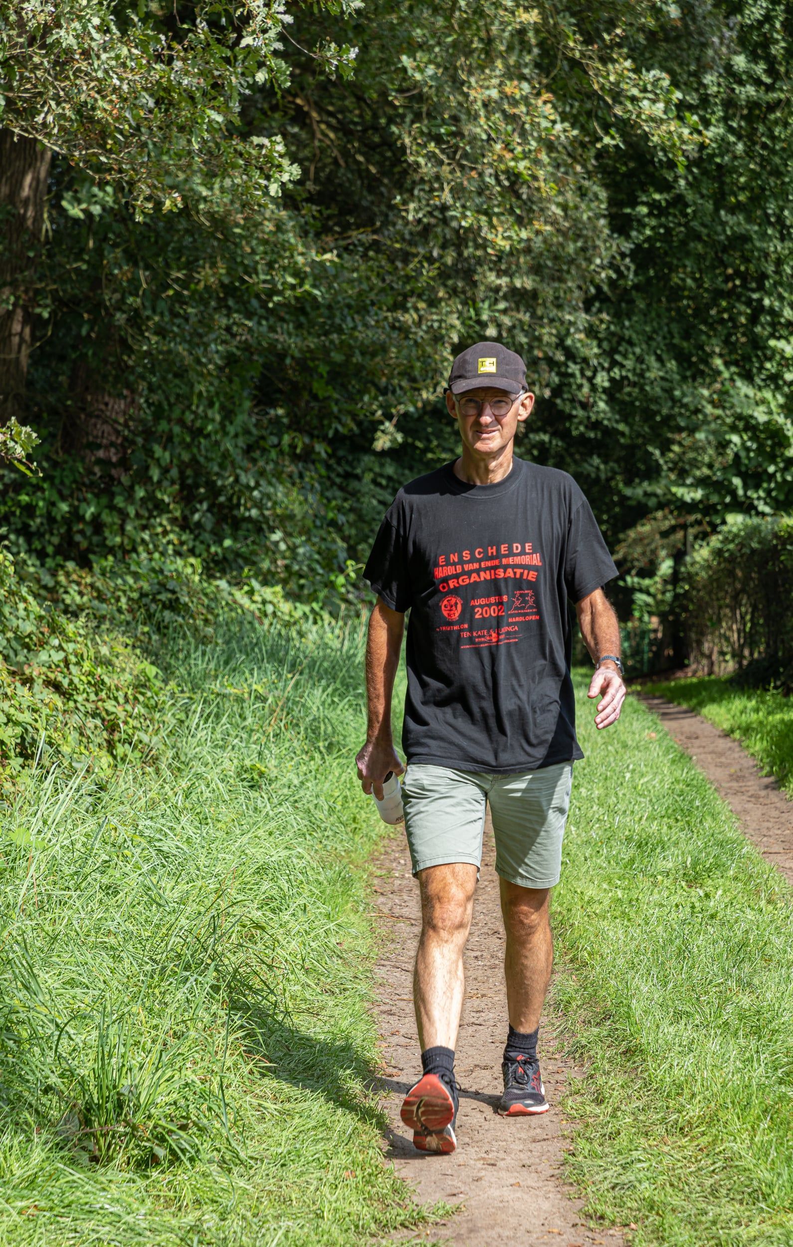 Een man loopt over een pad in het bos.