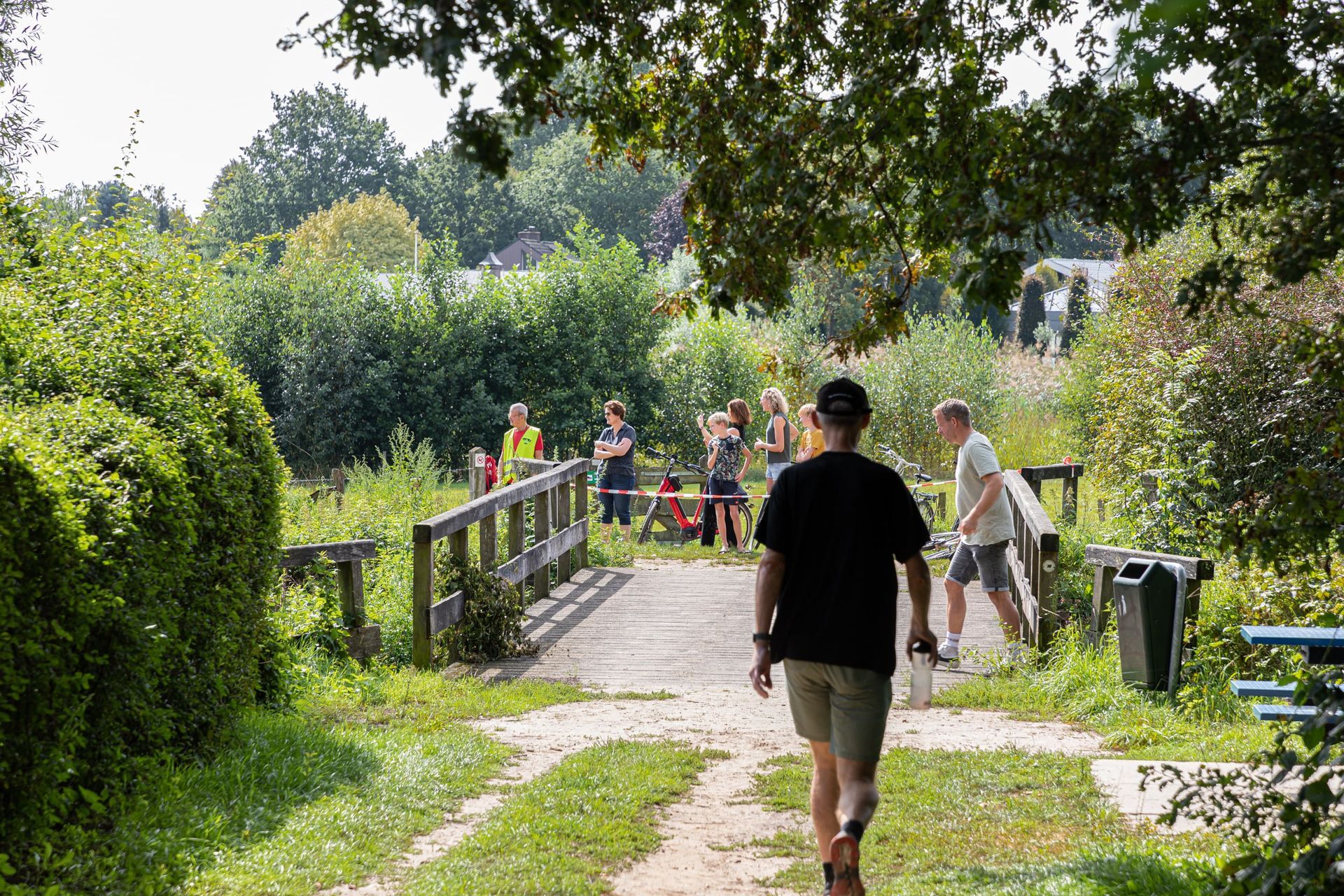Een man loopt over een pad in een park.