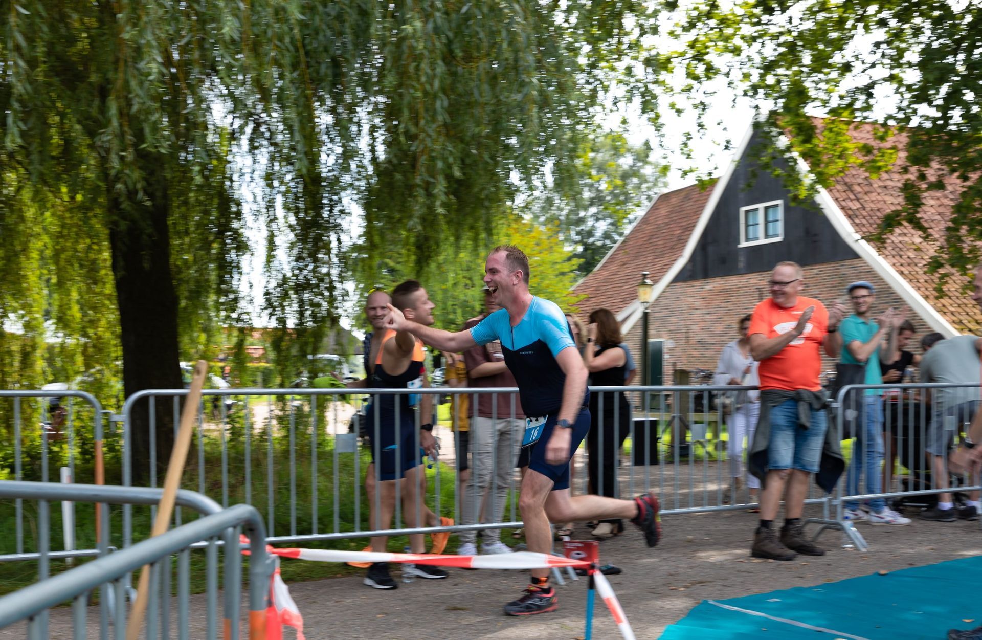 Een man doet mee aan een race en krijgt een high five van een groep mensen.