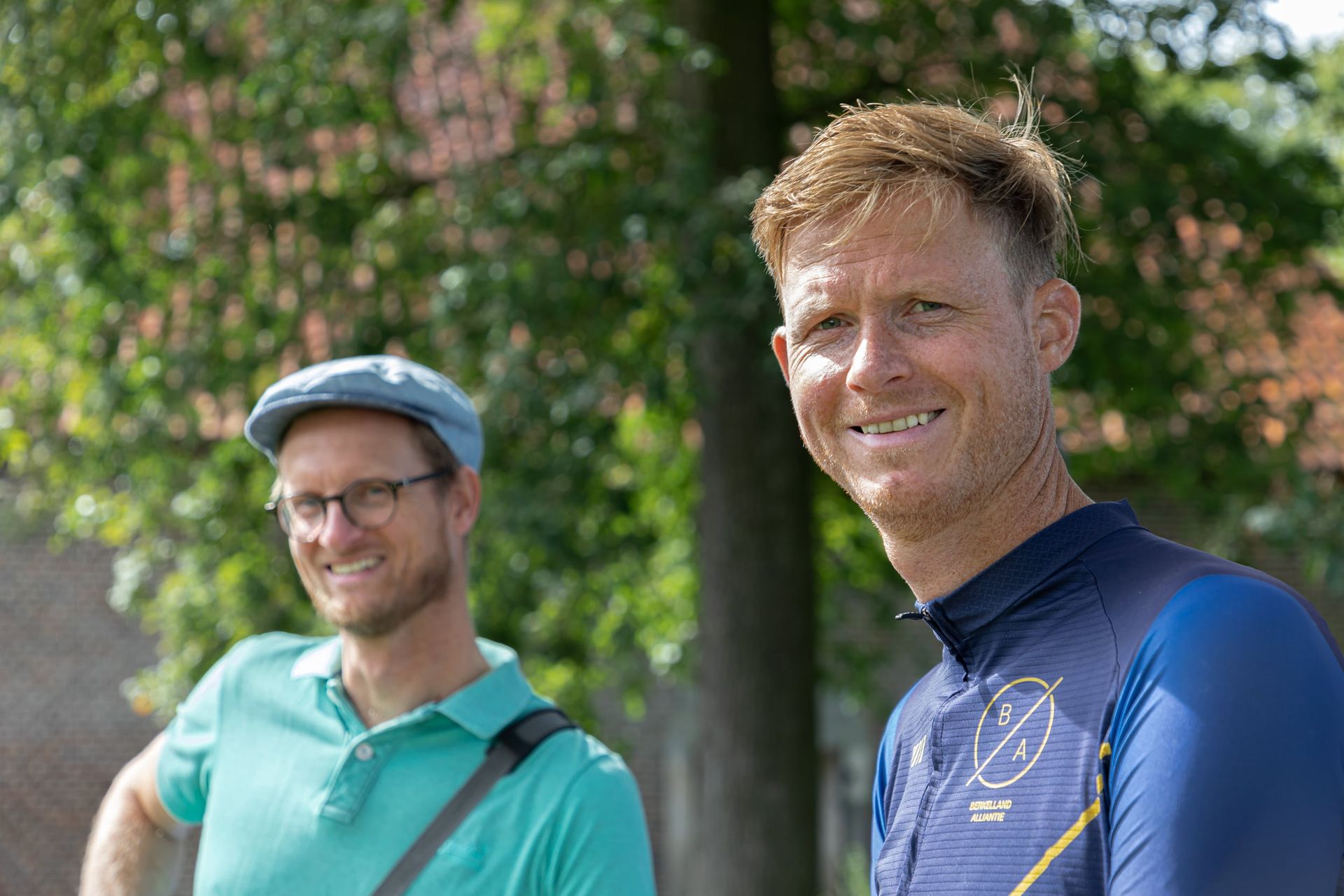Prijsuitreiking Triathlon Eibergen 2023. Twee mannen staan ​​naast elkaar in een park en lachen naar de camera.
