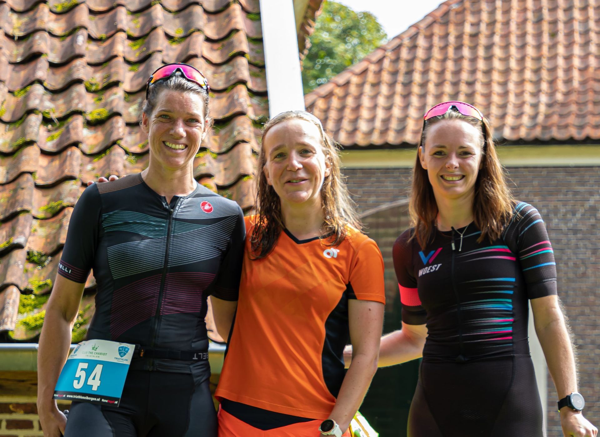Prijsuitreiking Triathlon Eibergen 2023. Drie vrouwen poseren voor een foto voor een pannendak.