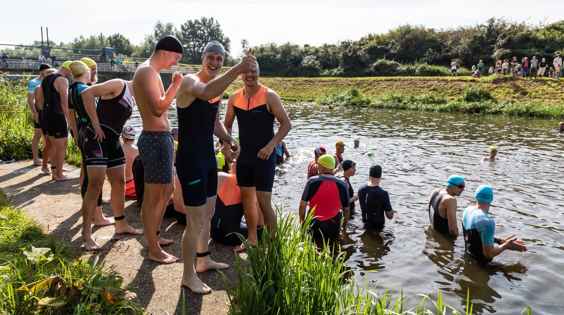 Een groep mensen staat naast een watermassa.