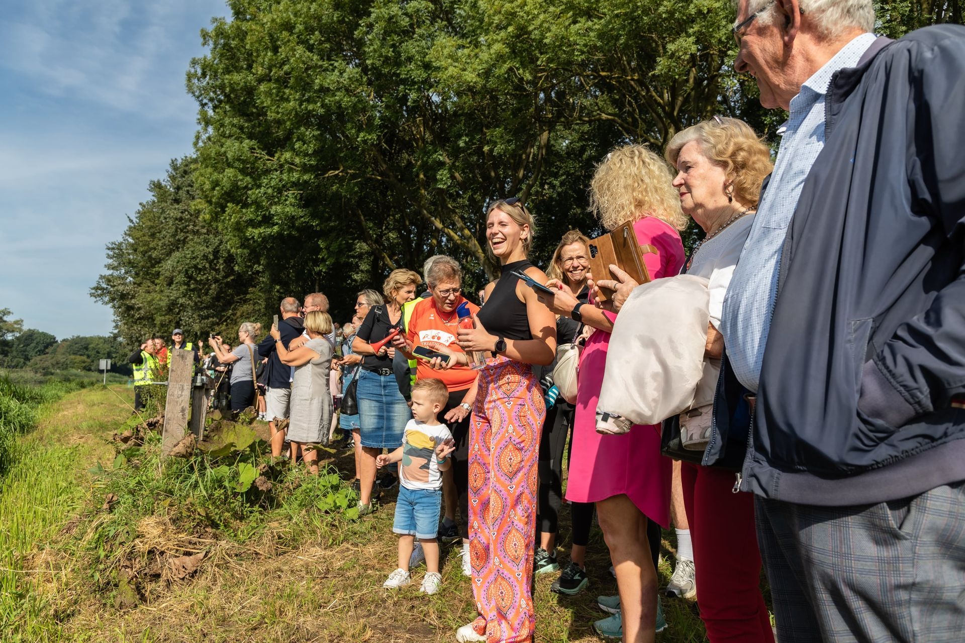 Een grote groep mensen staat in een veld.