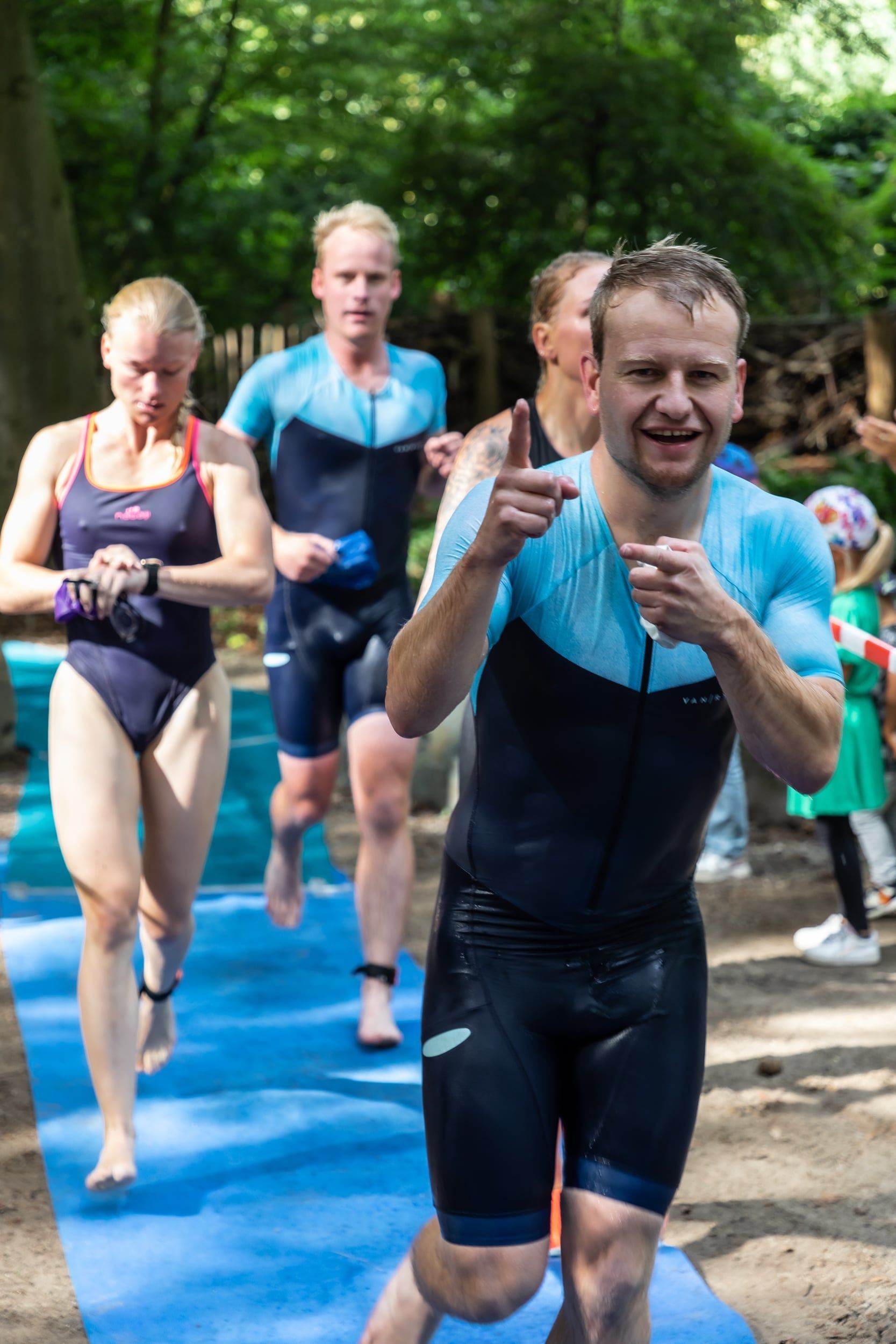 Een groep mensen rent op een blauwe mat.