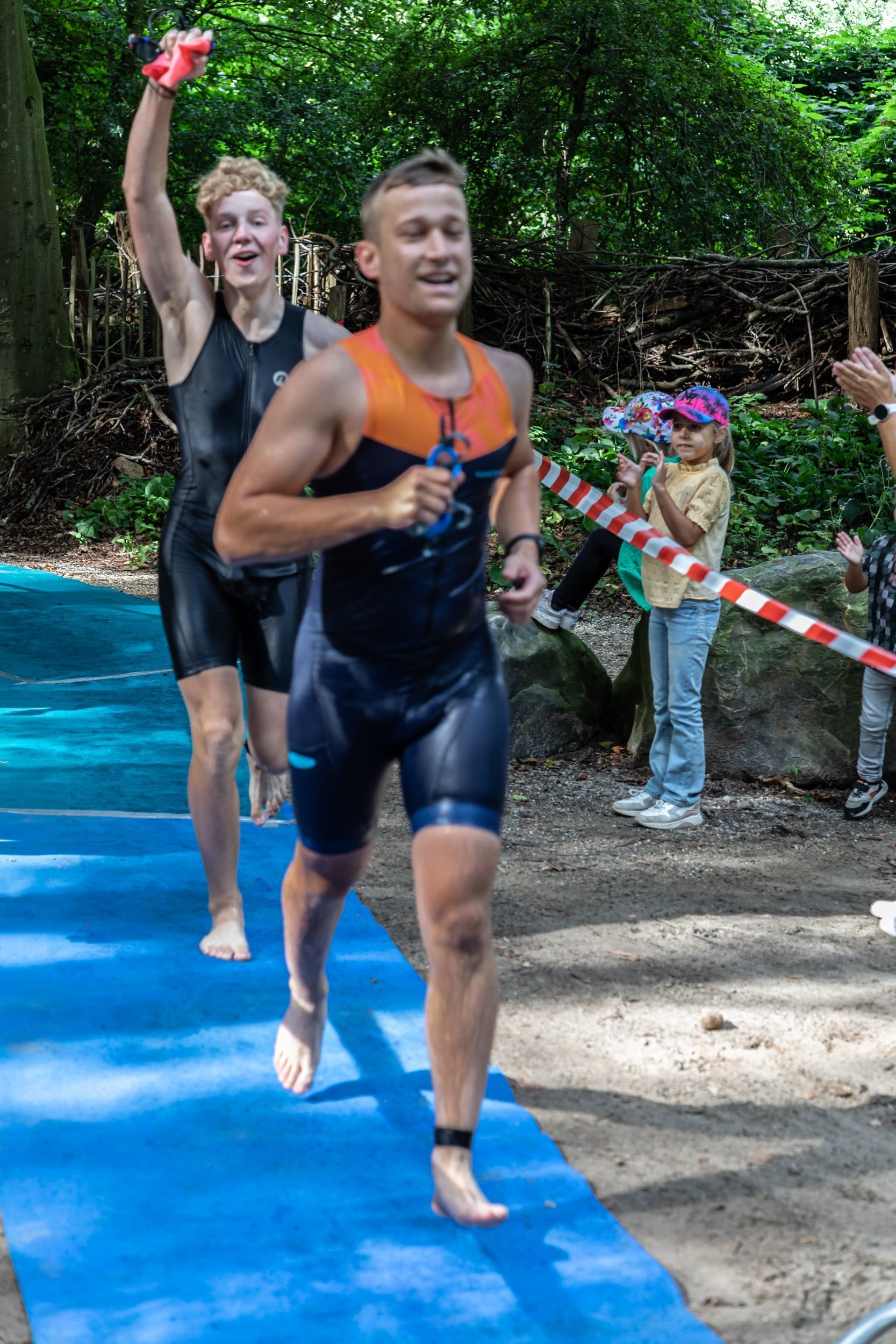 Een groep mannen rent op een blauwe mat.