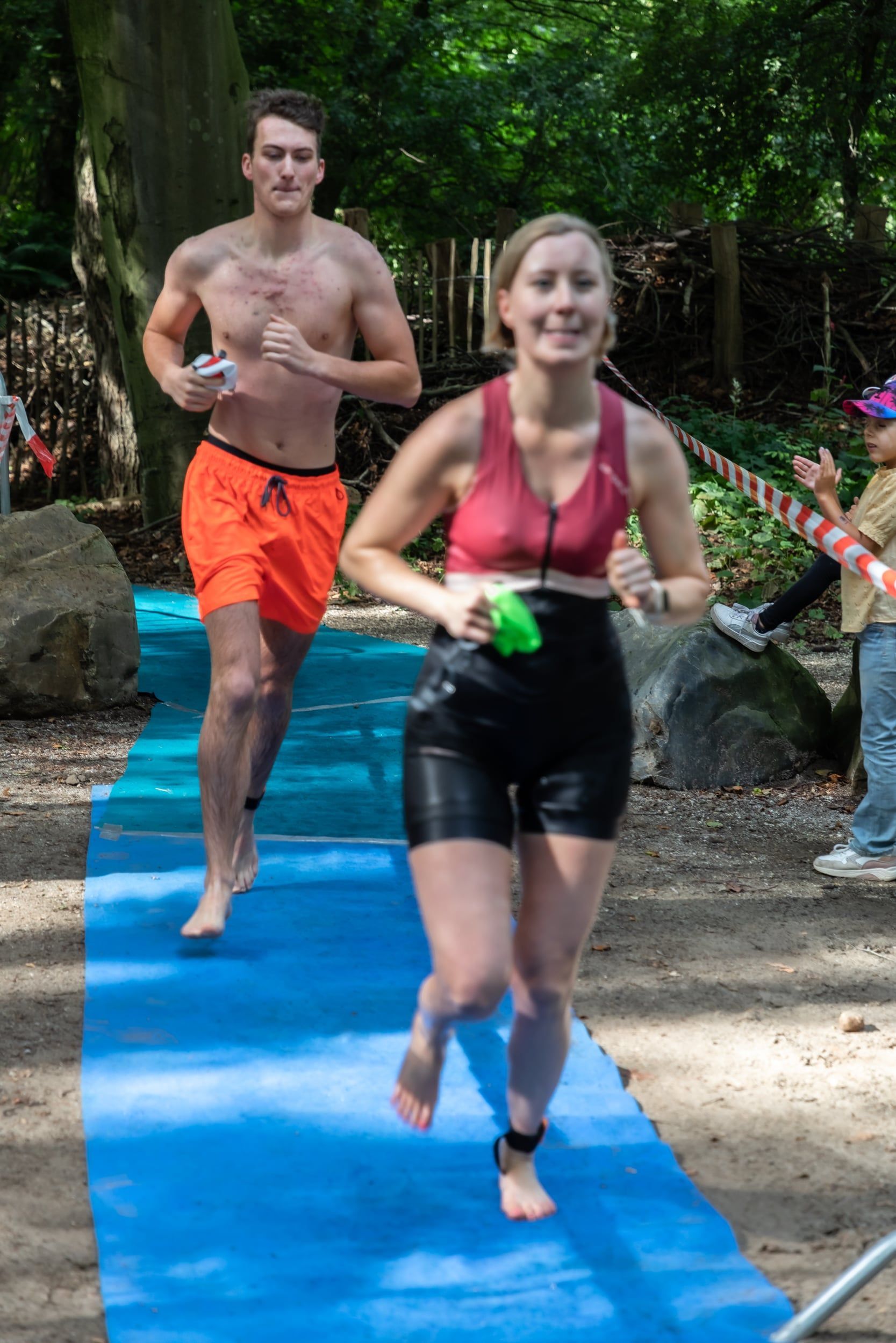 Een man en een vrouw rennen op een blauwe mat.