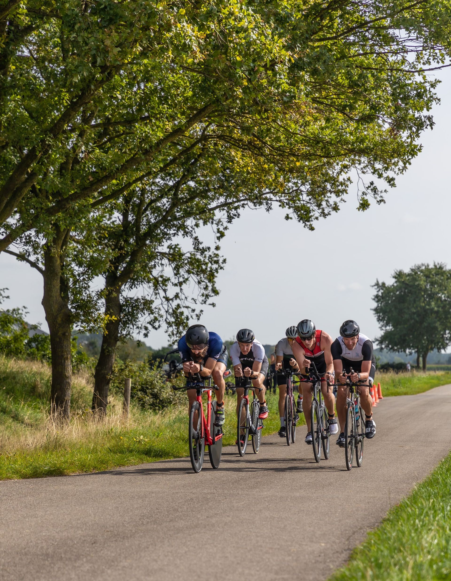 Een groep mensen fietst over een weg.